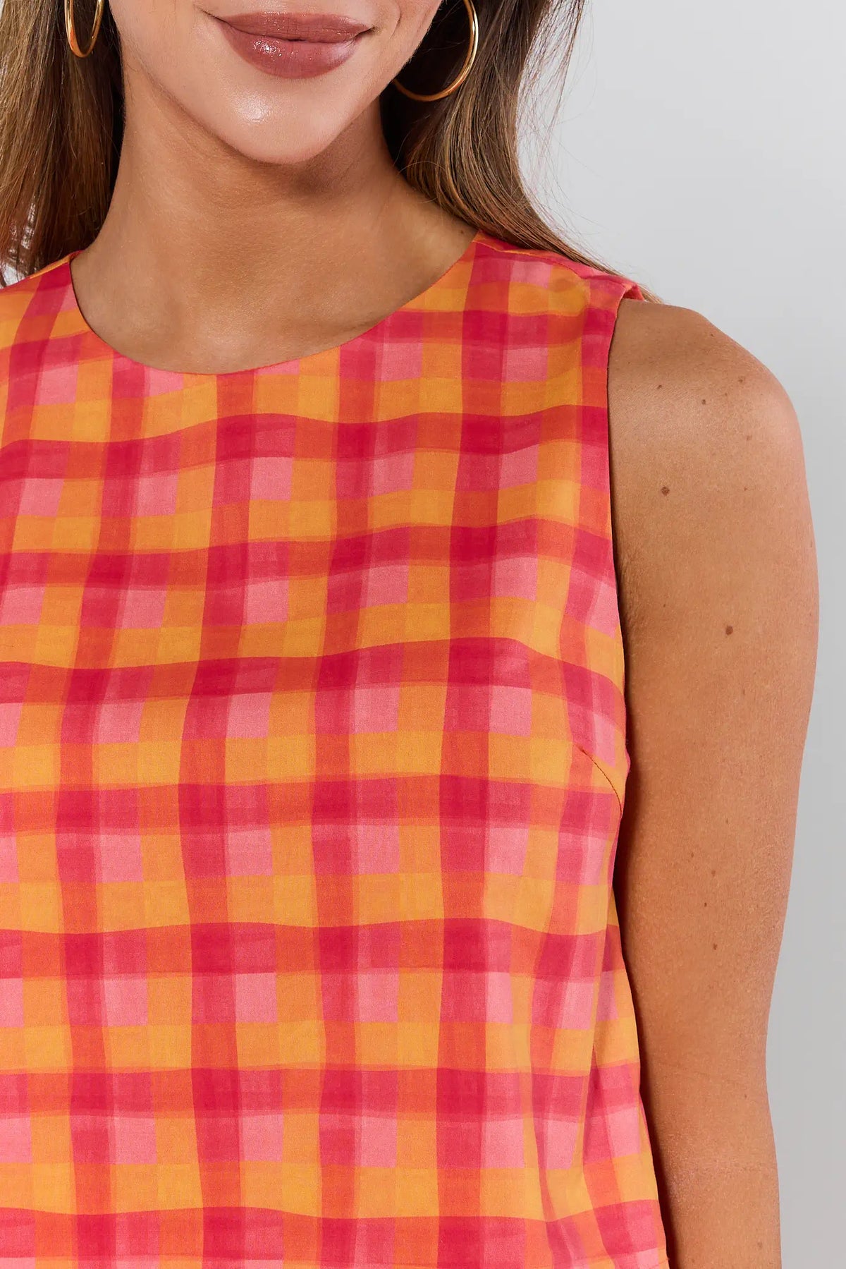 Orange plaid tank top close-up detail, round neckline and multicolor checkered print | Avara