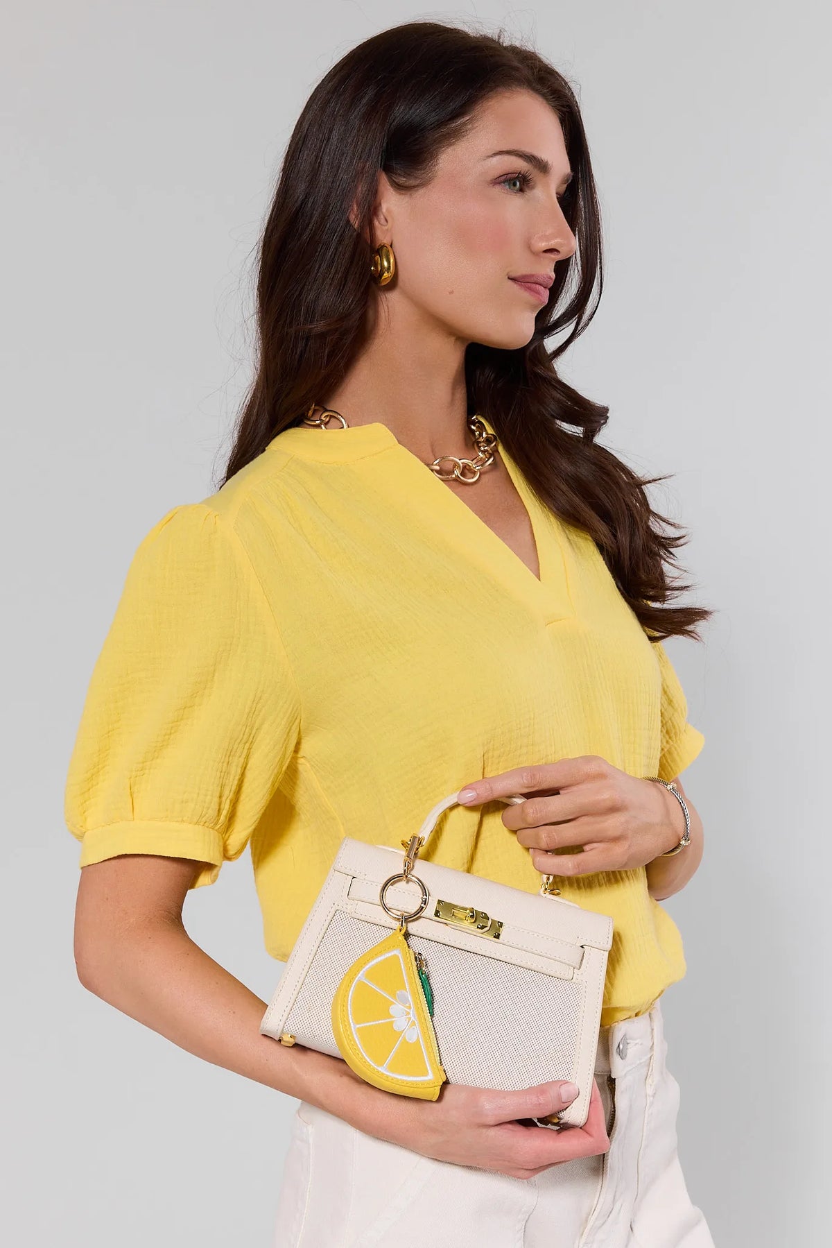 Yellow lemon purse charm clipped onto cream structured handbag - Styled Look | Avara