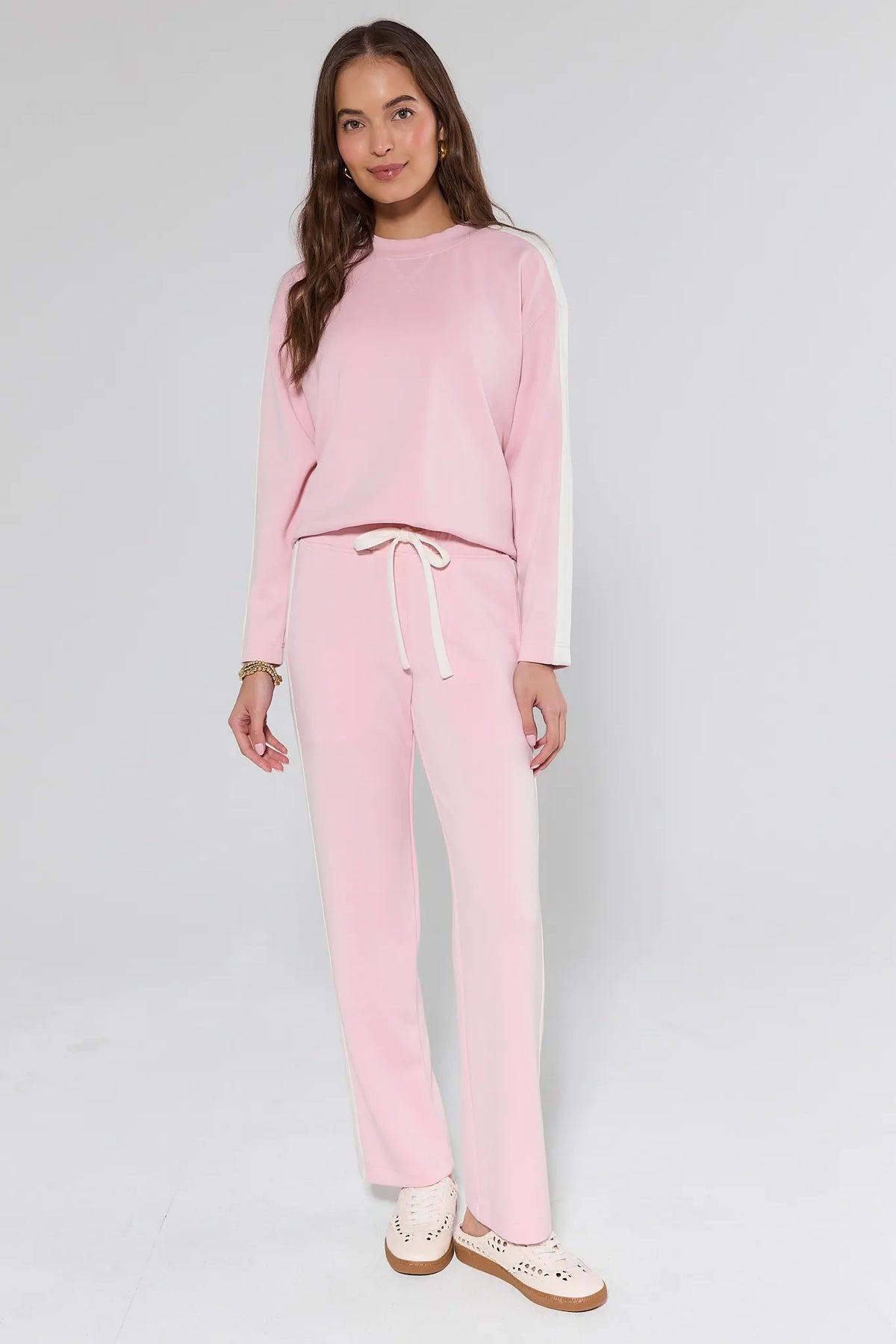 Katelyn Pink Stripe Lounge Pants styled with matching pink pullover and cream sneakers - Full Length On Model | Avara