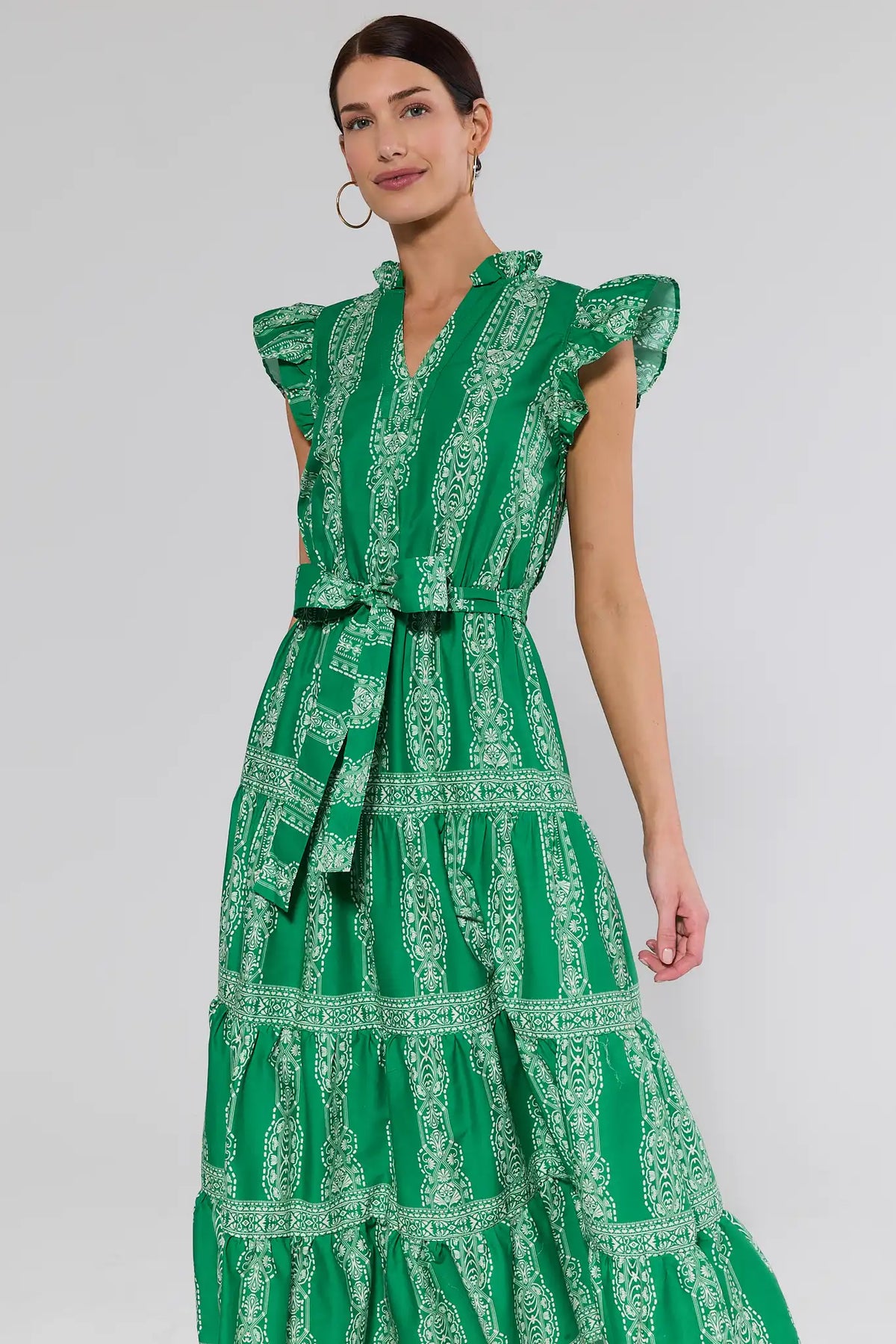 Woman wearing a green patterned dress on a white background
