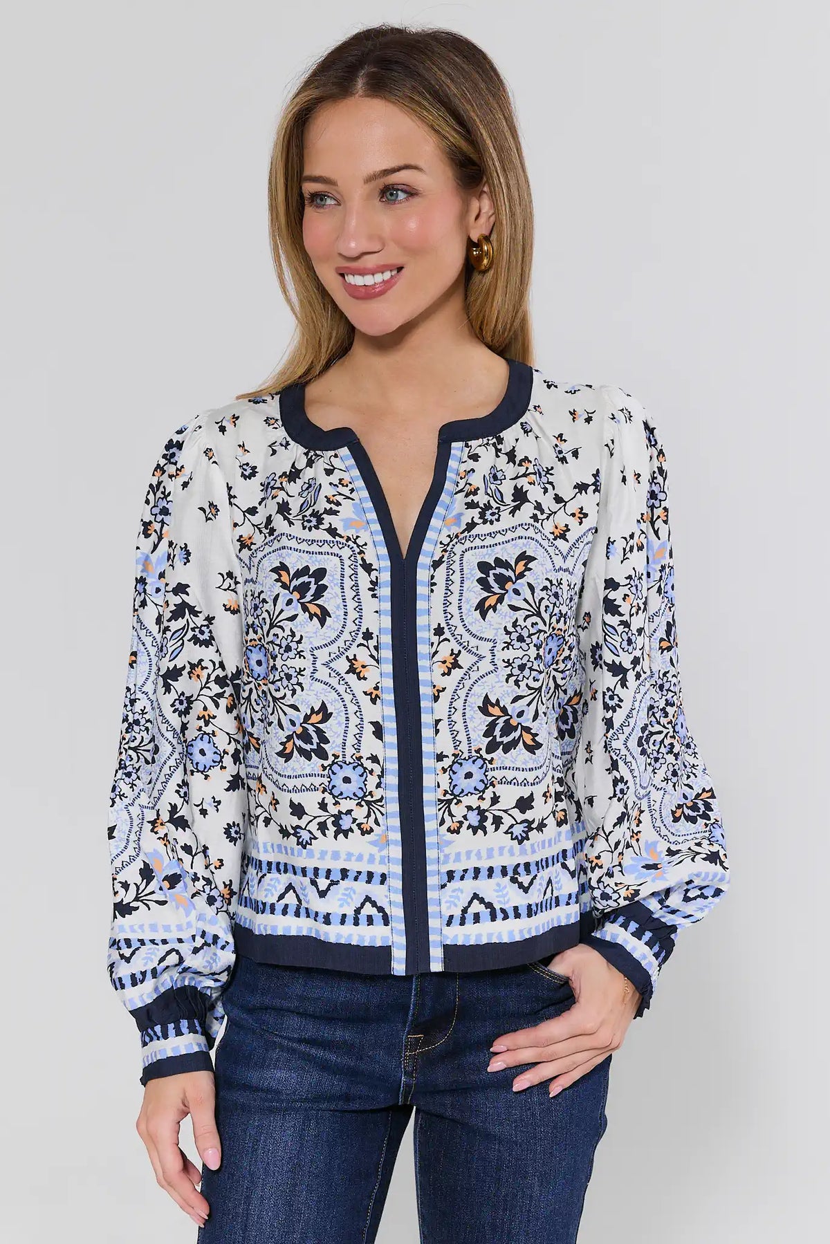 Woman wearing a patterned blouse with a plain background