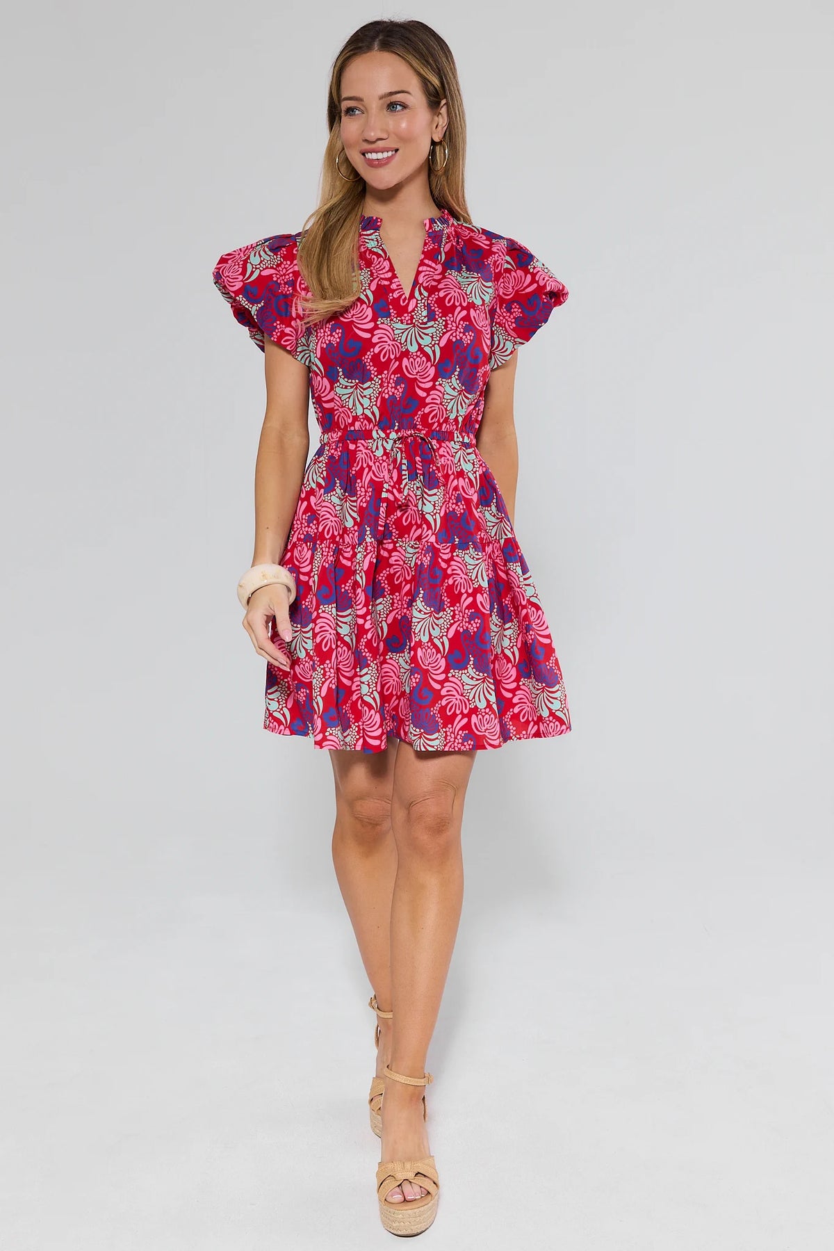 Woman wearing a pink and purple floral dress on a white background