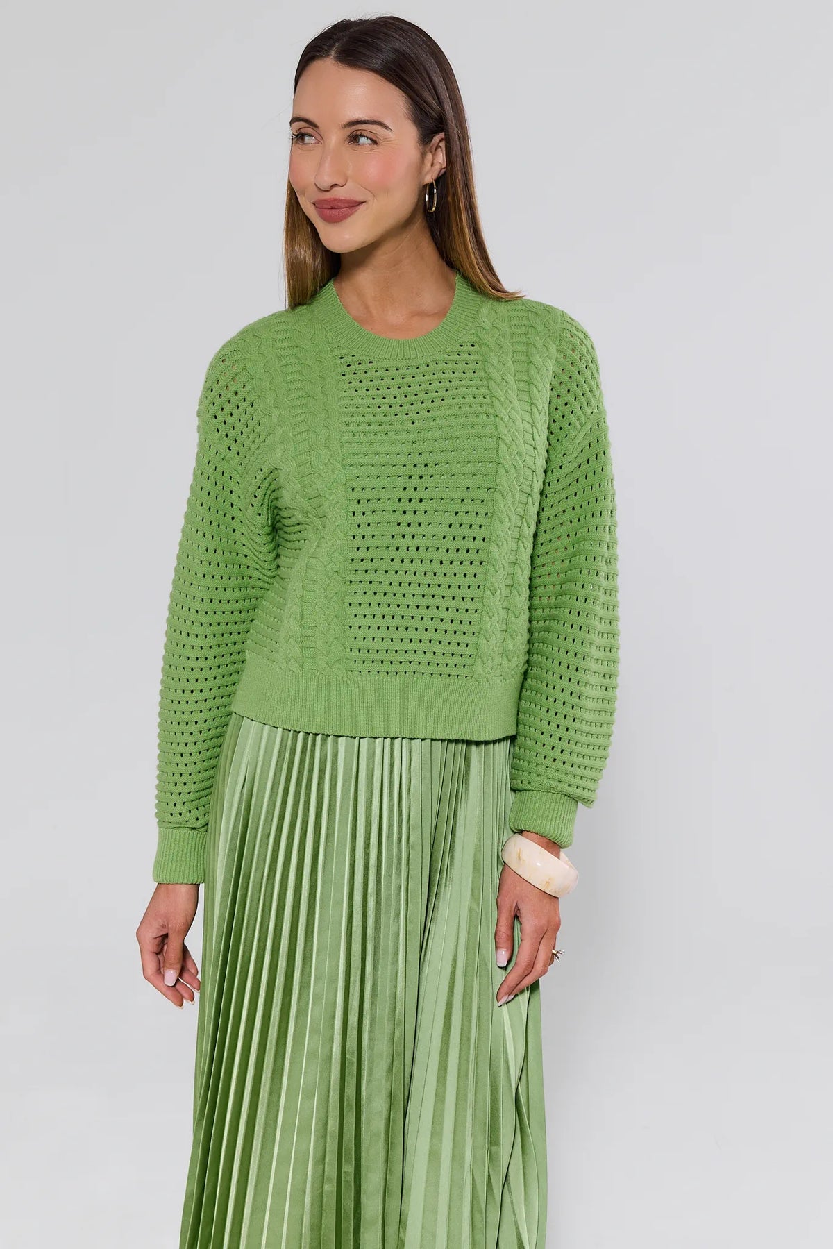 Green cable-knit sweater over pleated midi skirt two-piece set, three-quarter front angle | Avara