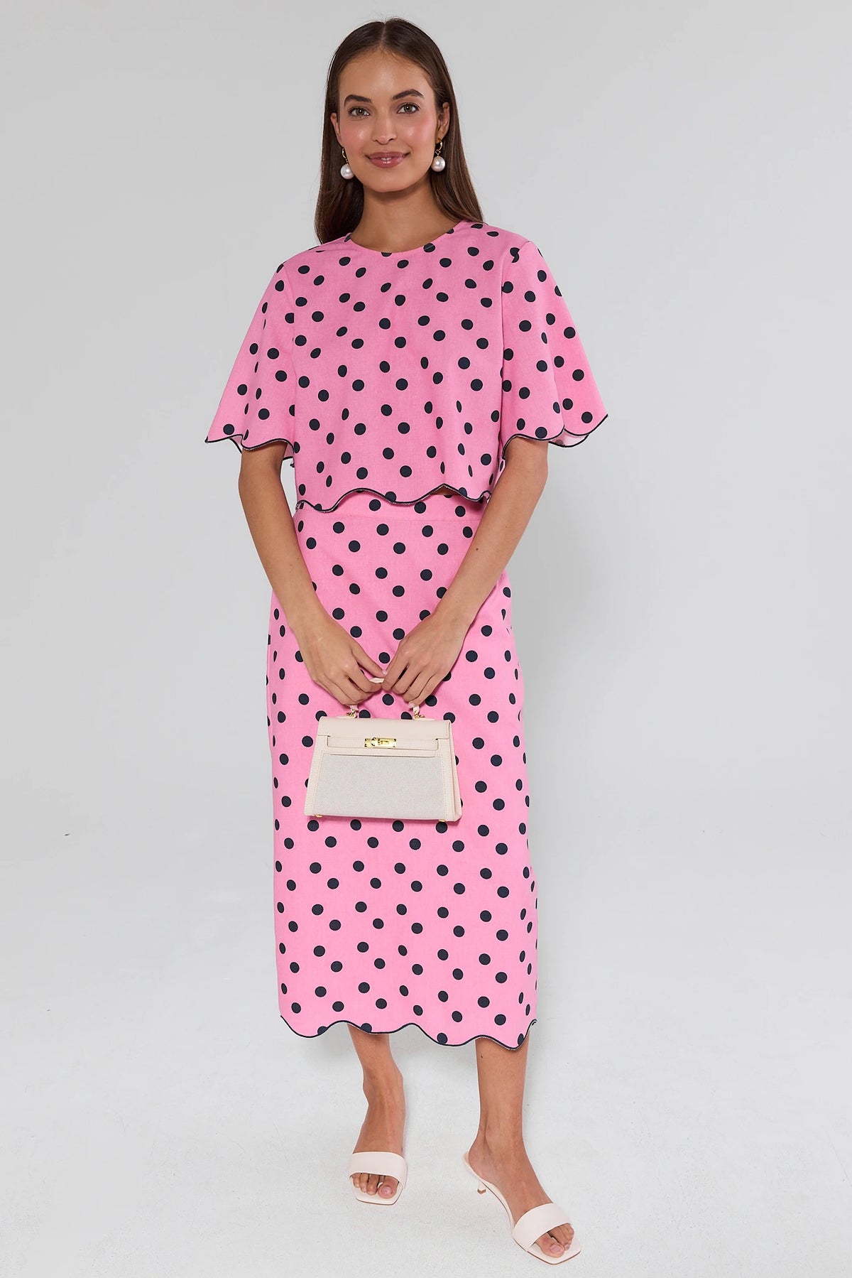 Maryl Pink Polka Dot Top - Full Front View on model with cream handbag, cropped silhouette and matching midi skirt | Avara