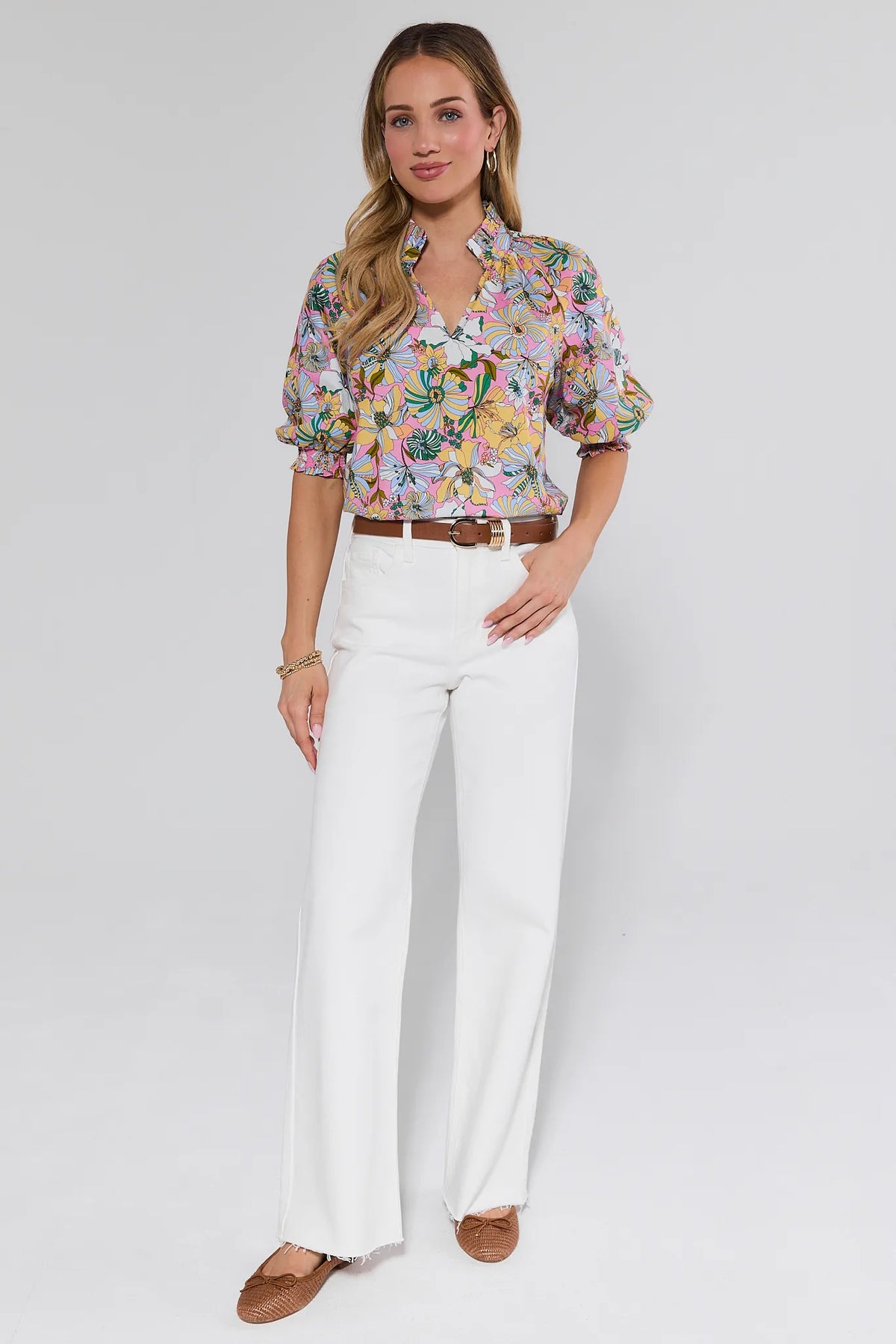 Model wearing Serena White Straight Leg Jeans with high rise and raw-edge hem, styled with a floral blouse and brown belt - Full Look | Avara