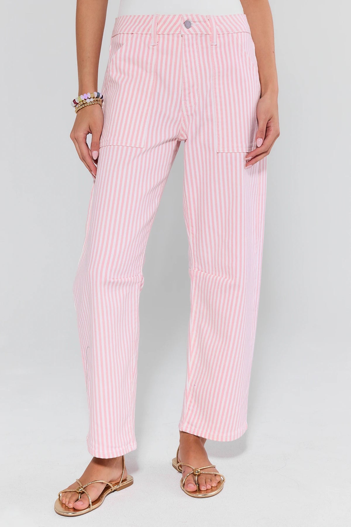 Pink striped pants worn by a person on a white background