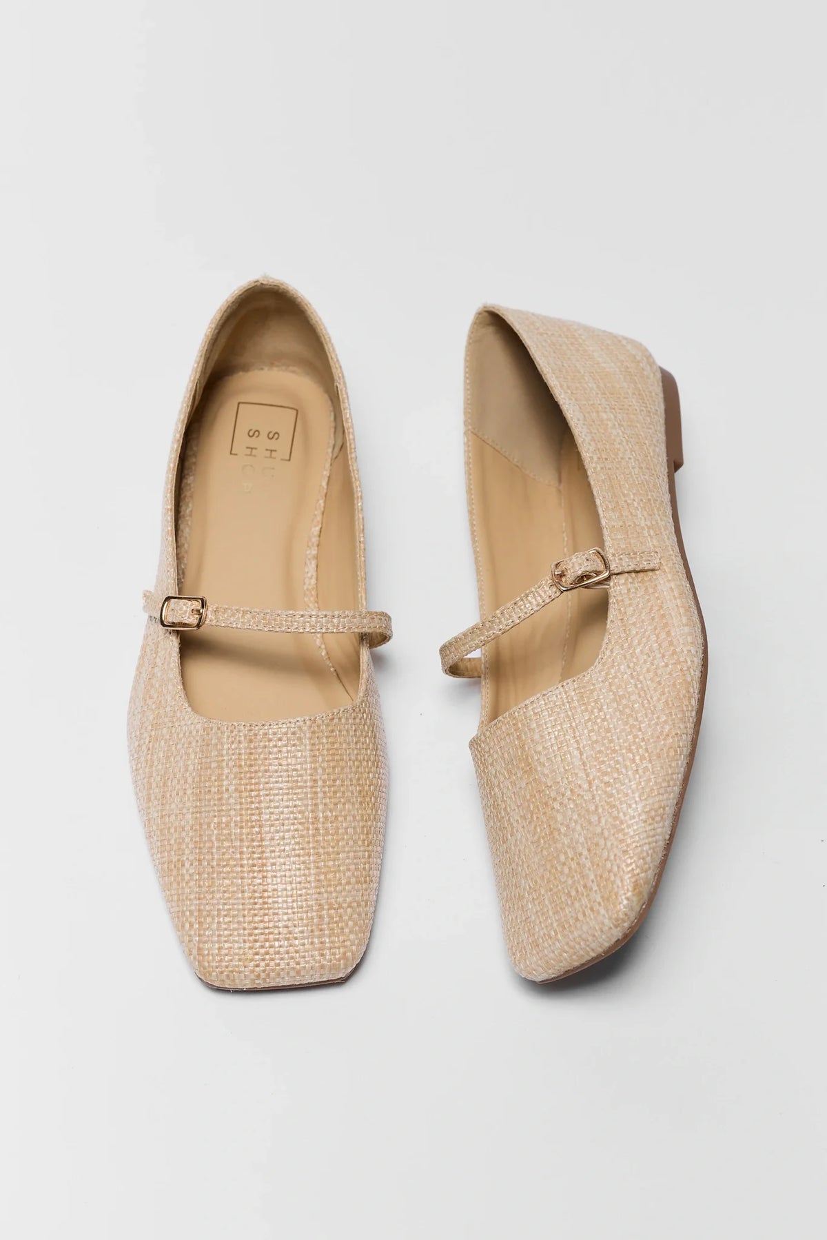 Beige flats with strap on a light gray background