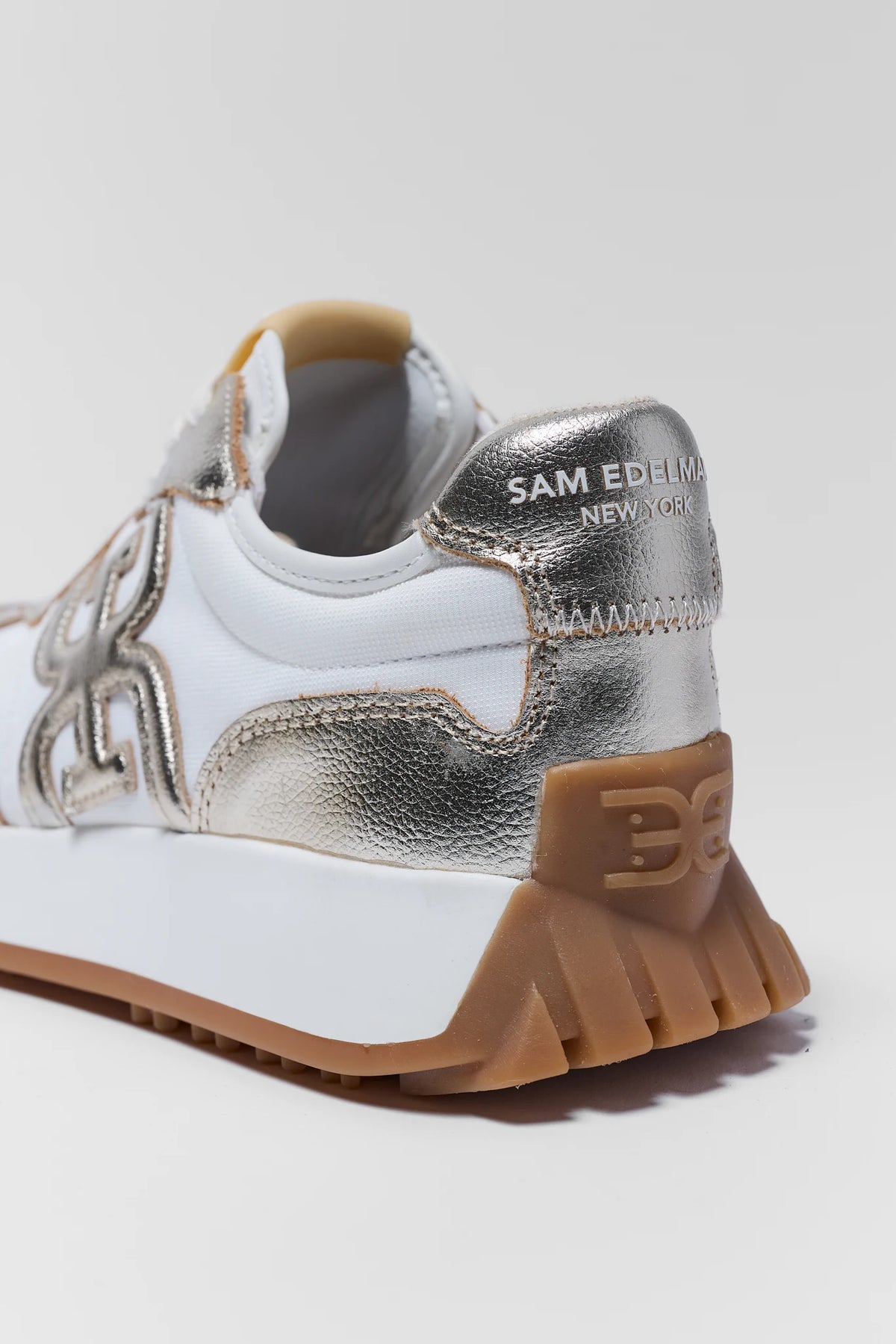Sam Edelman Langley Gold sneaker heel close-up with metallic counter and gum sole logo detail | Avara