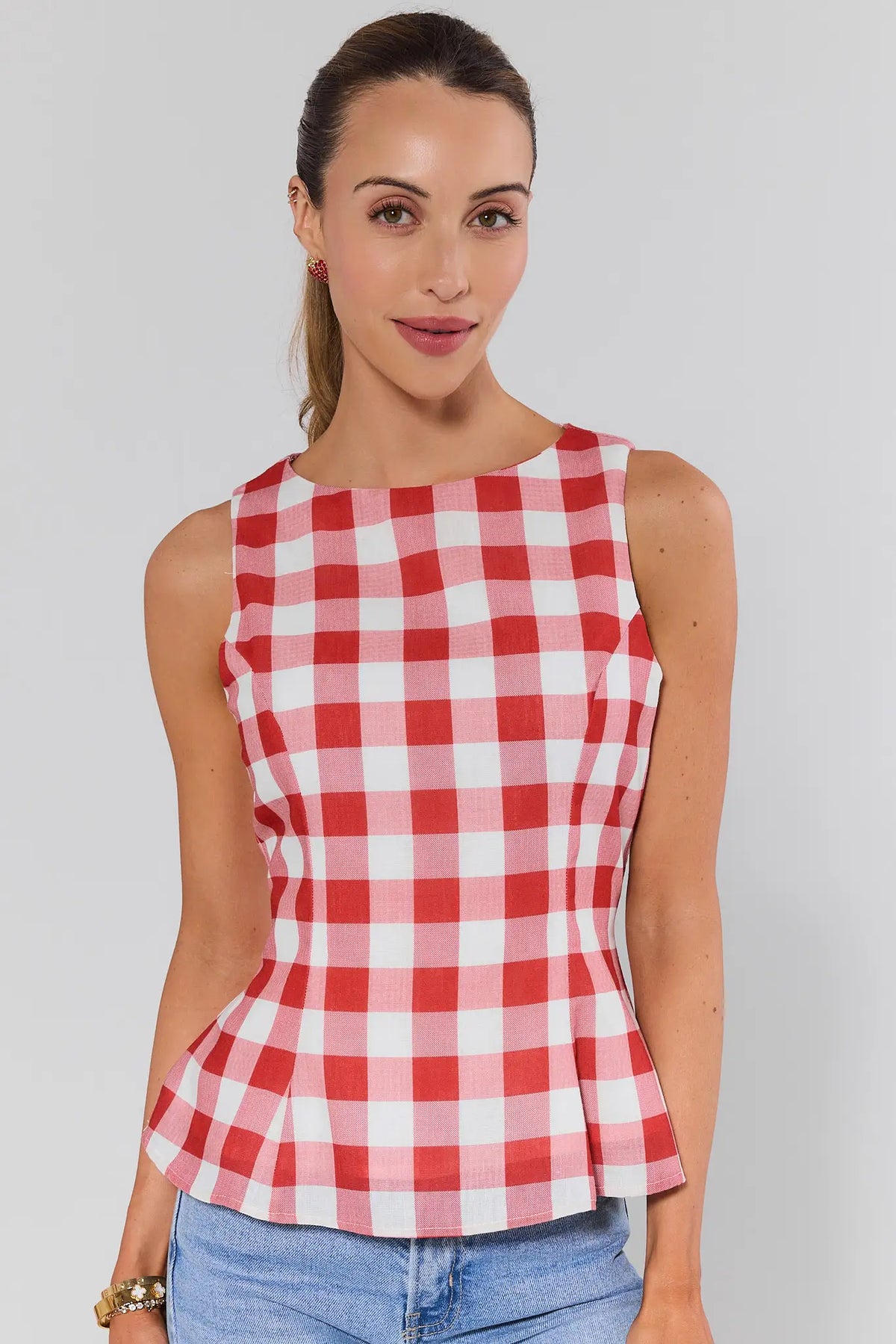 Woman wearing red gingham top with peplum hem and boat neckline, front view | Avara