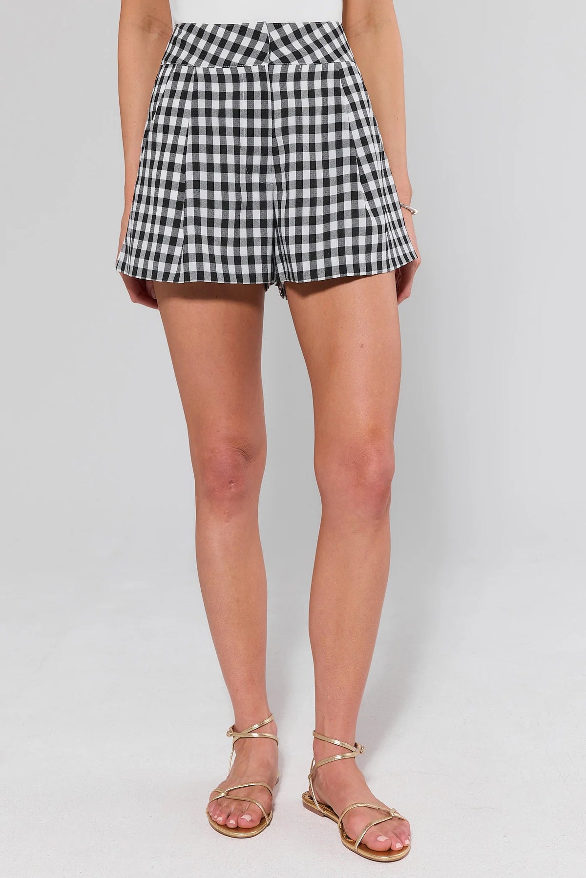 Black and white gingham shorts styled with white tank and gold sandals, front view on model | Avara
