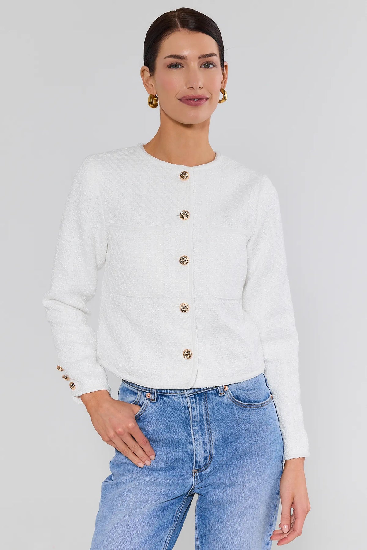 Woman wearing white tweed knit cardigan with gold buttons and blue jeans - Front View | Avara
