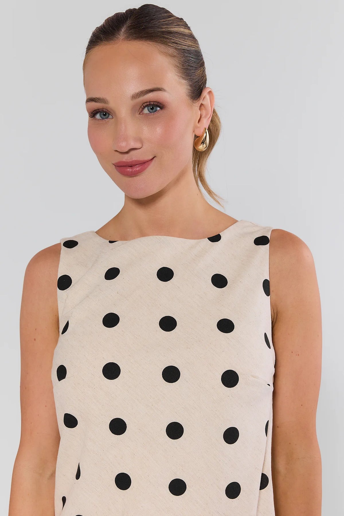 Close-up of cream polka dot short dress with boat neckline and black dots - Neckline Detail | Avara