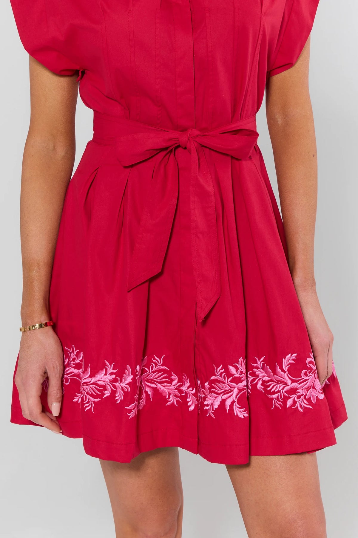 Red short dress with pink floral embroidered hem trim and tie waist bow - Close-Up Detail | Avara