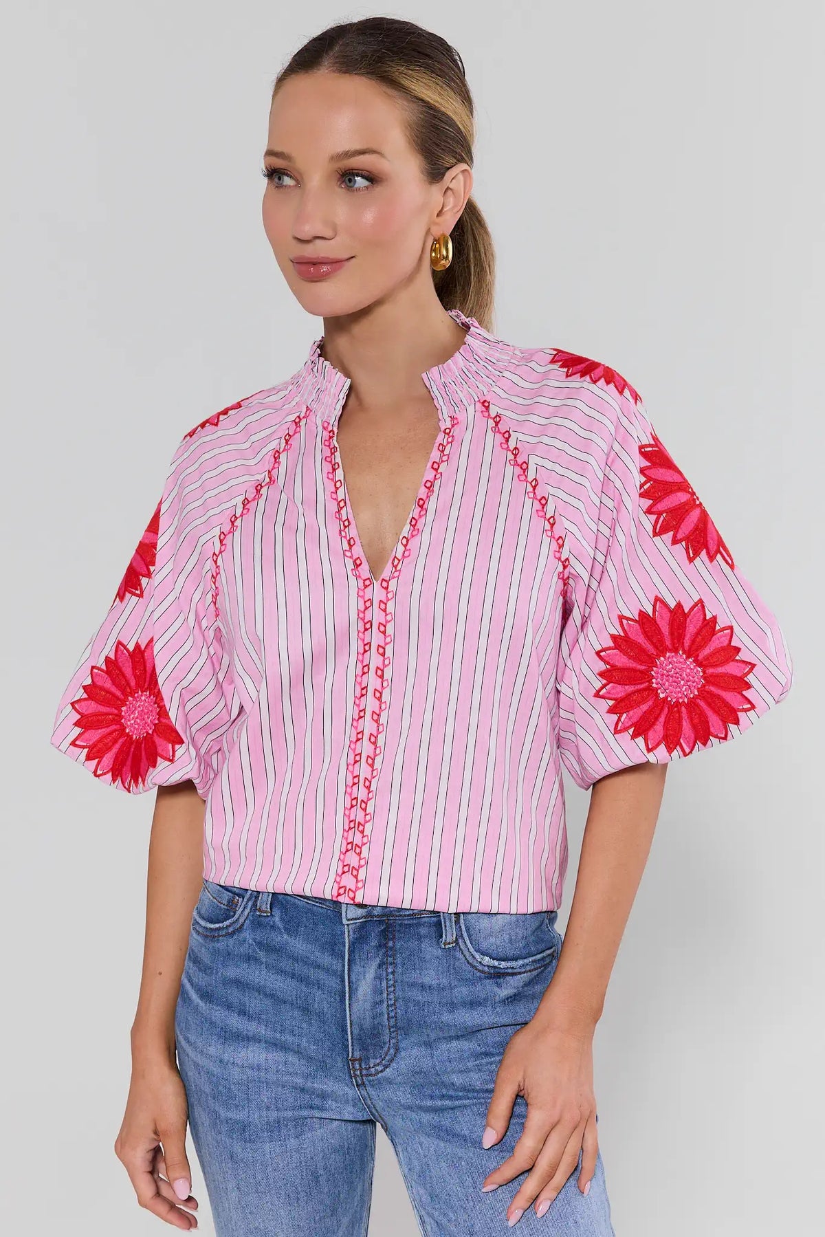 Woman wearing pink striped blouse with red floral embroidery, relaxed fit, front view - THML Krista Top | Avara