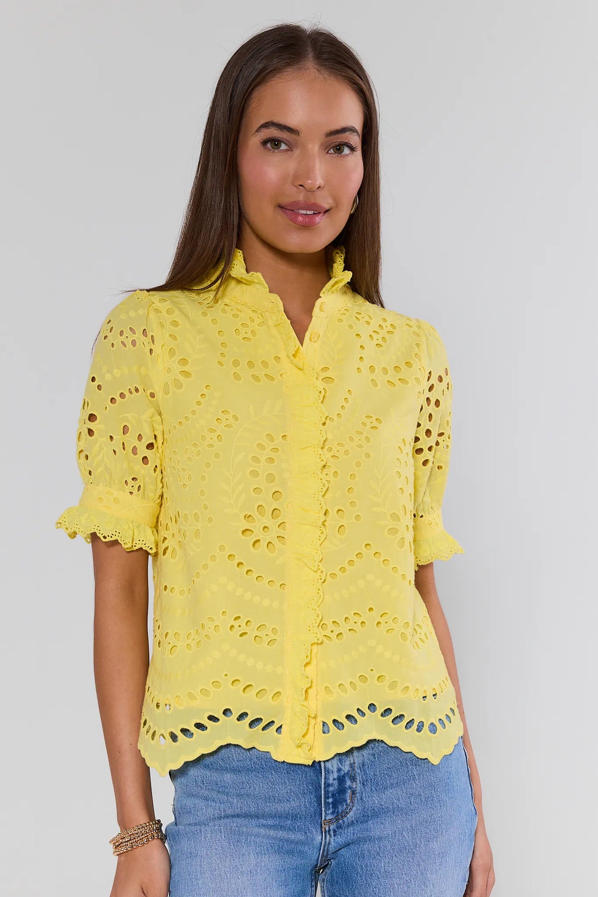 Yellow eyelet button-up blouse with ruffle collar on model with blue jeans - Front View | Avara
