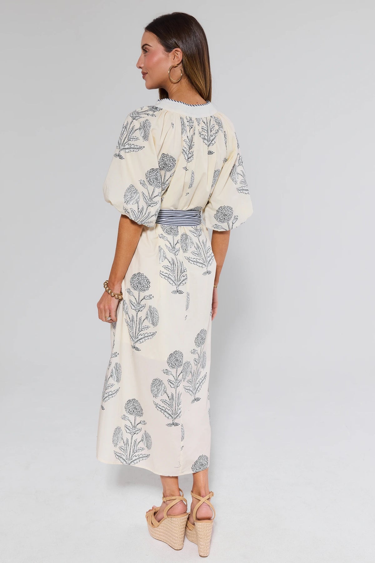 Woman wearing a floral dress on a plain background