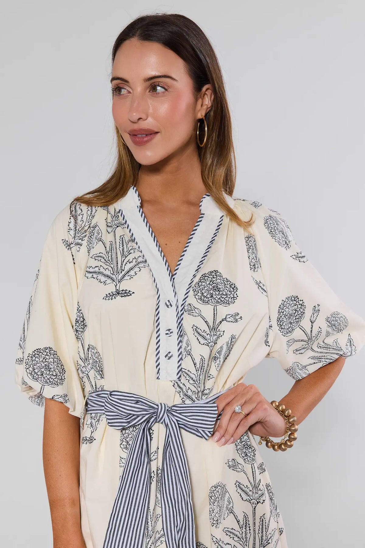 Woman wearing a floral kimono-style garment with a plain background