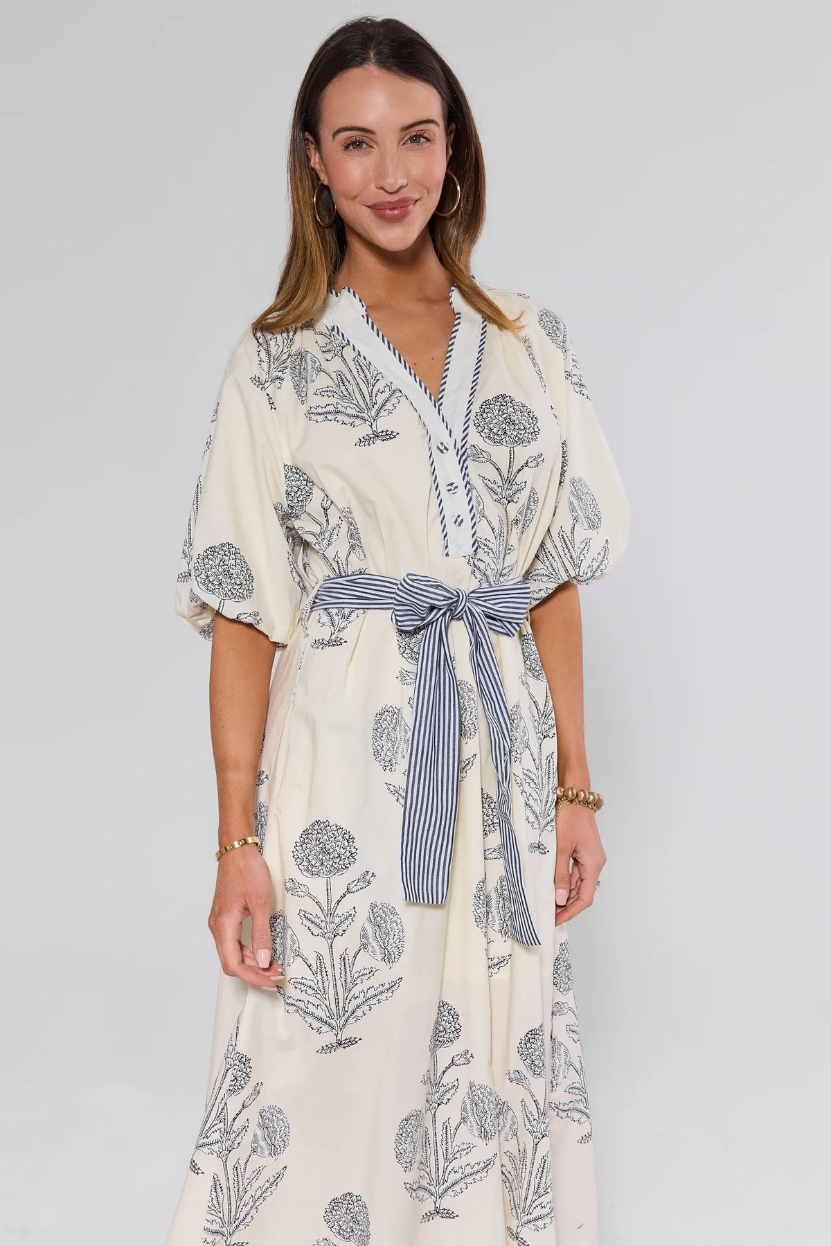 Woman wearing a floral kimono-style dress with a white background