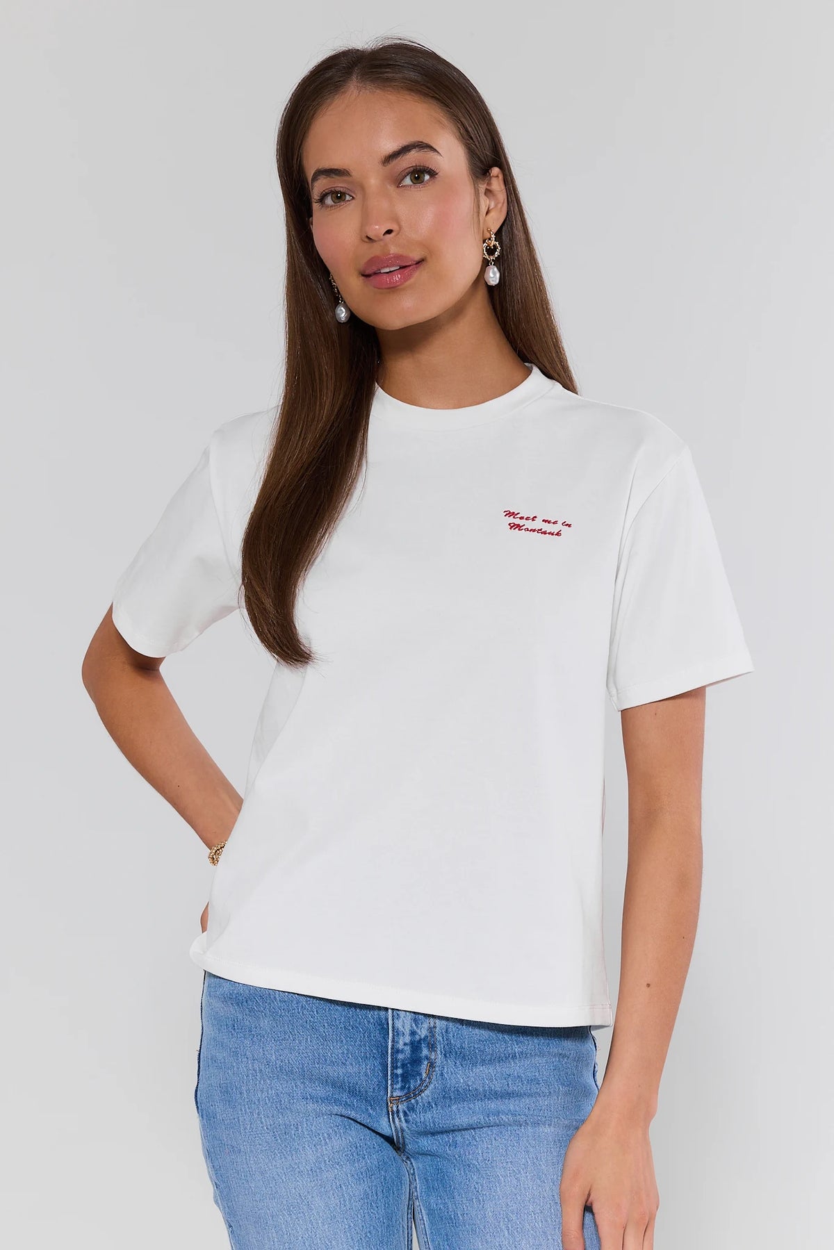 Montauk White Embroidered Tee with red script detail, styled with light wash jeans - Front View | Avara