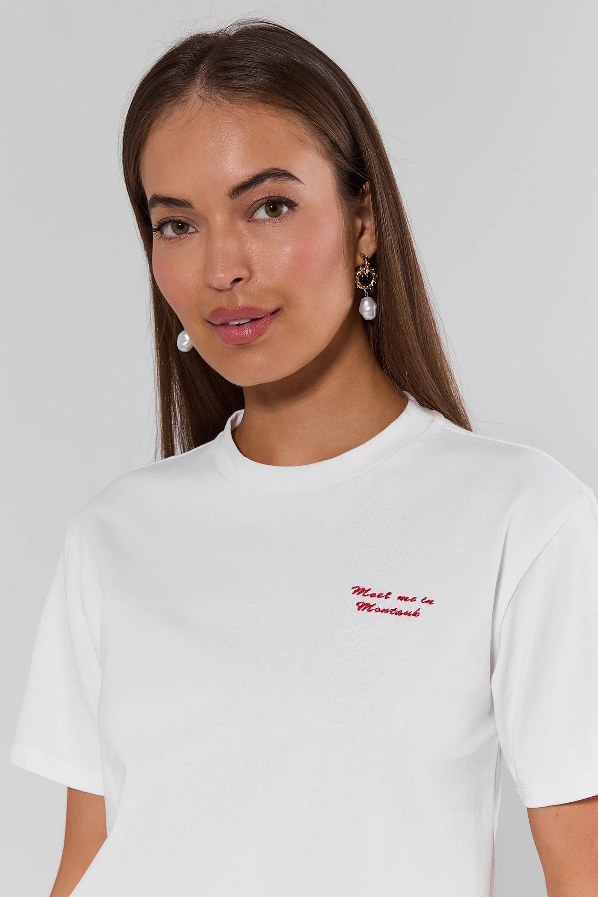 Montauk White Embroidered Tee close-up showing red Meet Me in Montauk script embroidery - Detail View | Avara