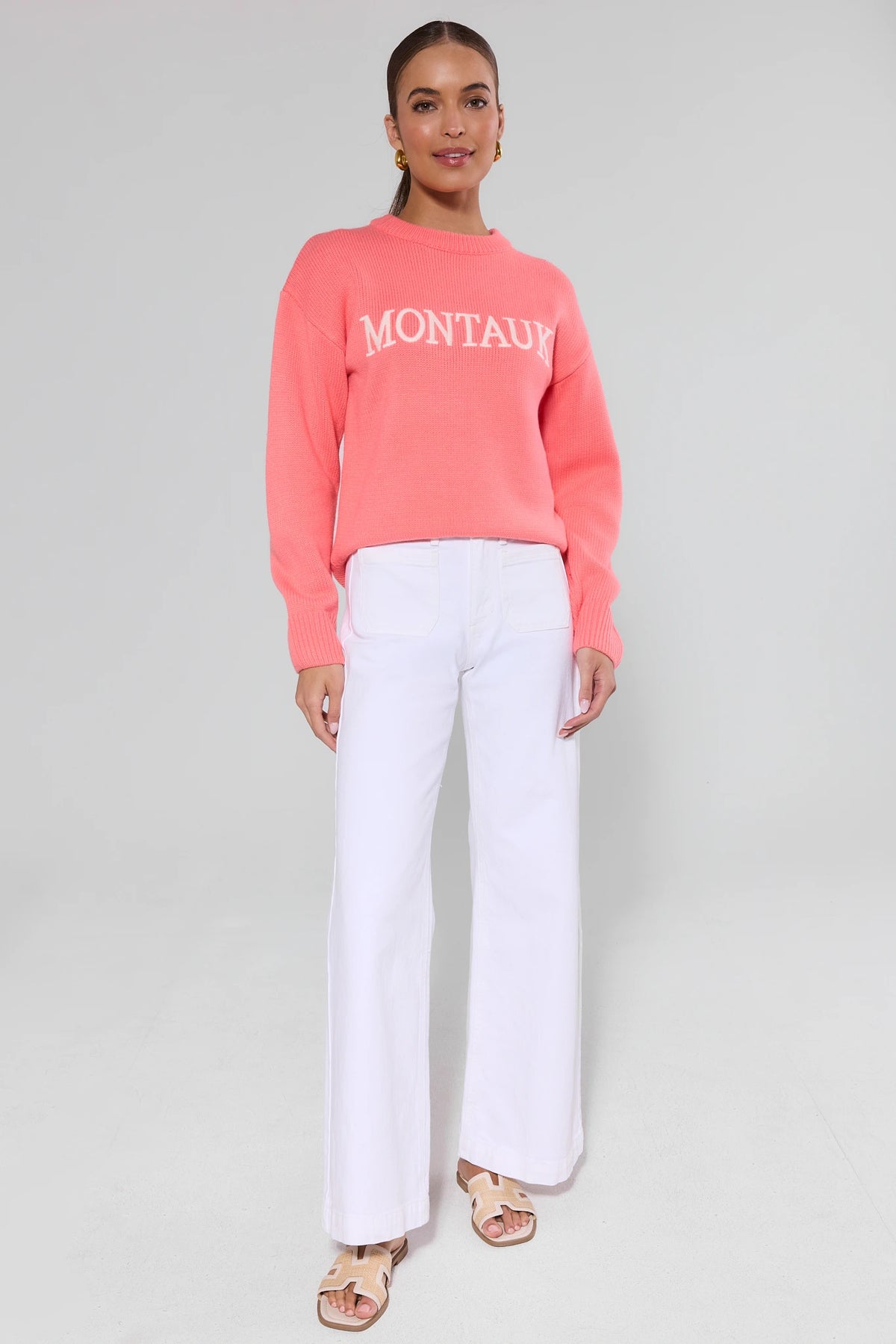 Montauk coral knit sweater full-body front view paired with white wide-leg pants and sandals | Avara