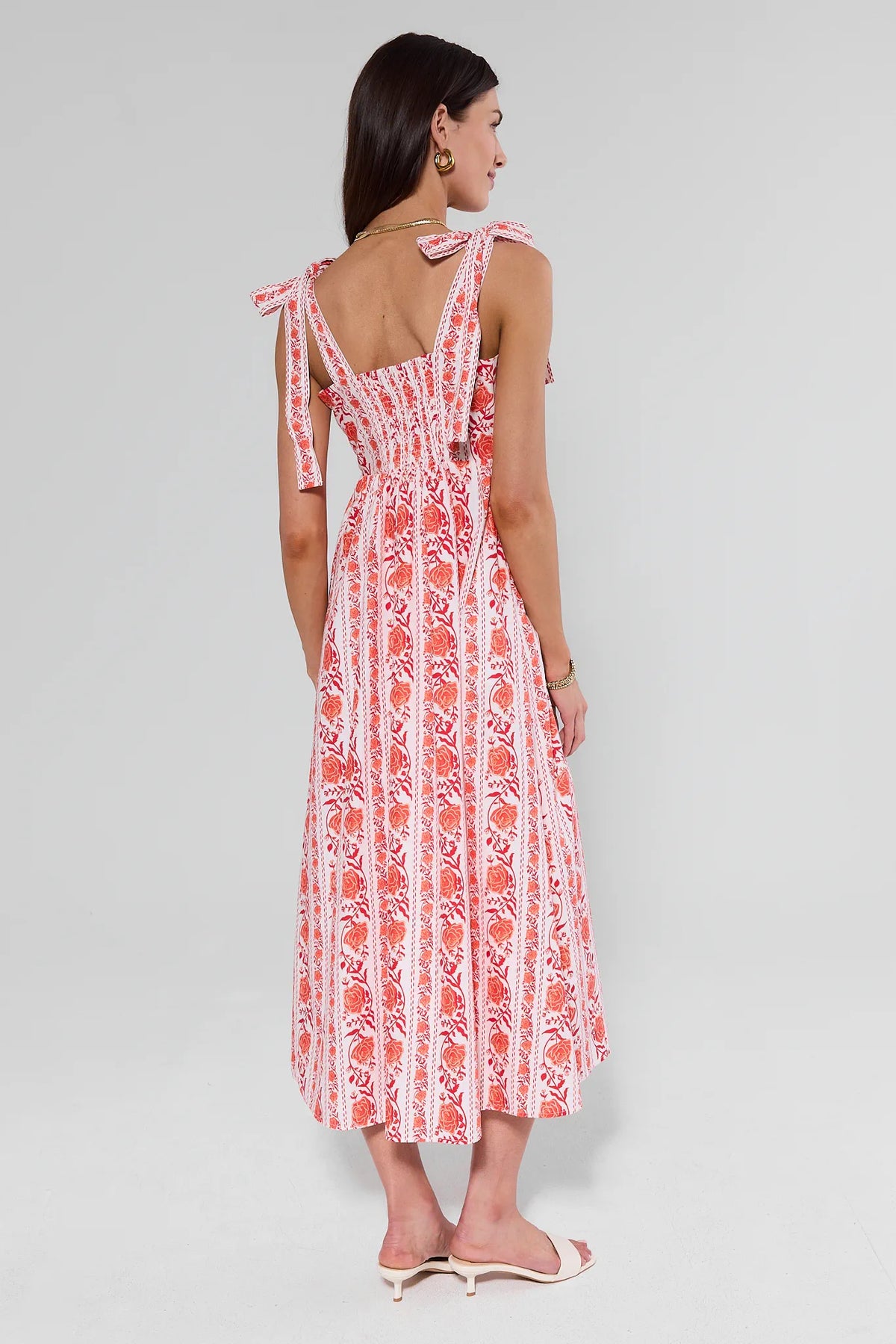 Woman wearing a red and white patterned dress on a gray background