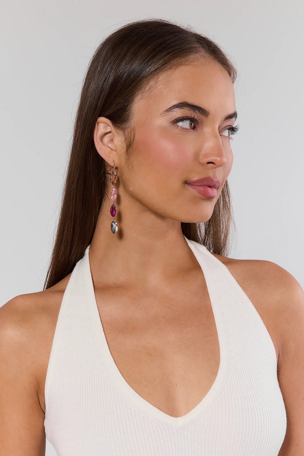 Woman wearing Raquel pink stone drop earrings with gold setting, side profile on model | Avara