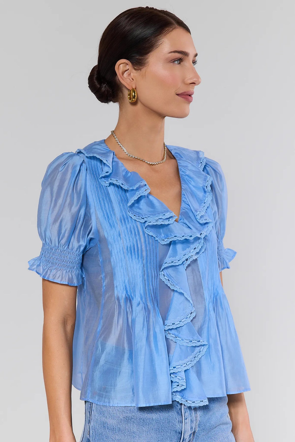 Light blue ruffle top with smocked sleeves and pintuck pleating - Side View with Gold Jewelry | Avara