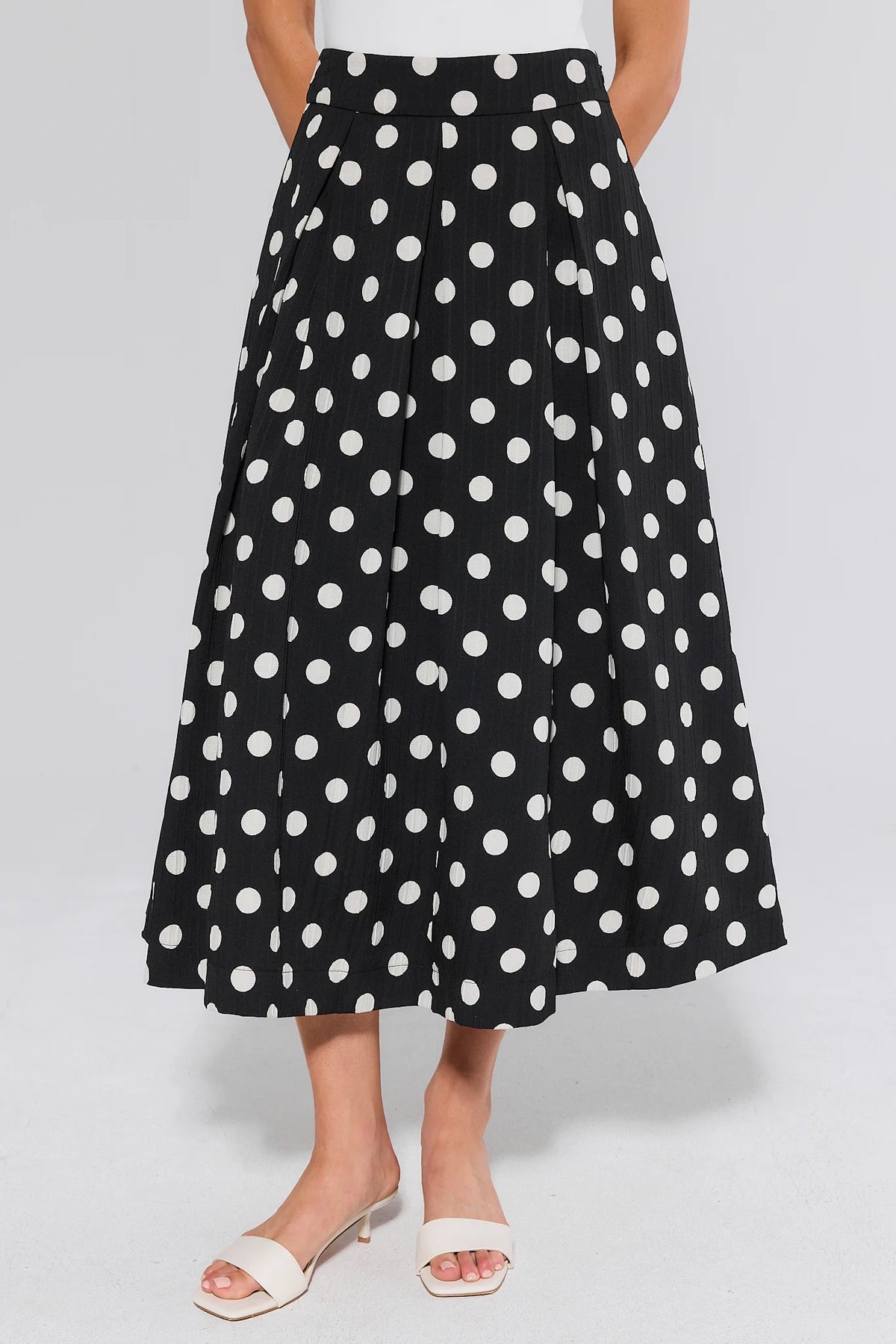 Collins Black Polka Dot Pleated Midi Skirt - Front View, On Model with White Sandals | Avara