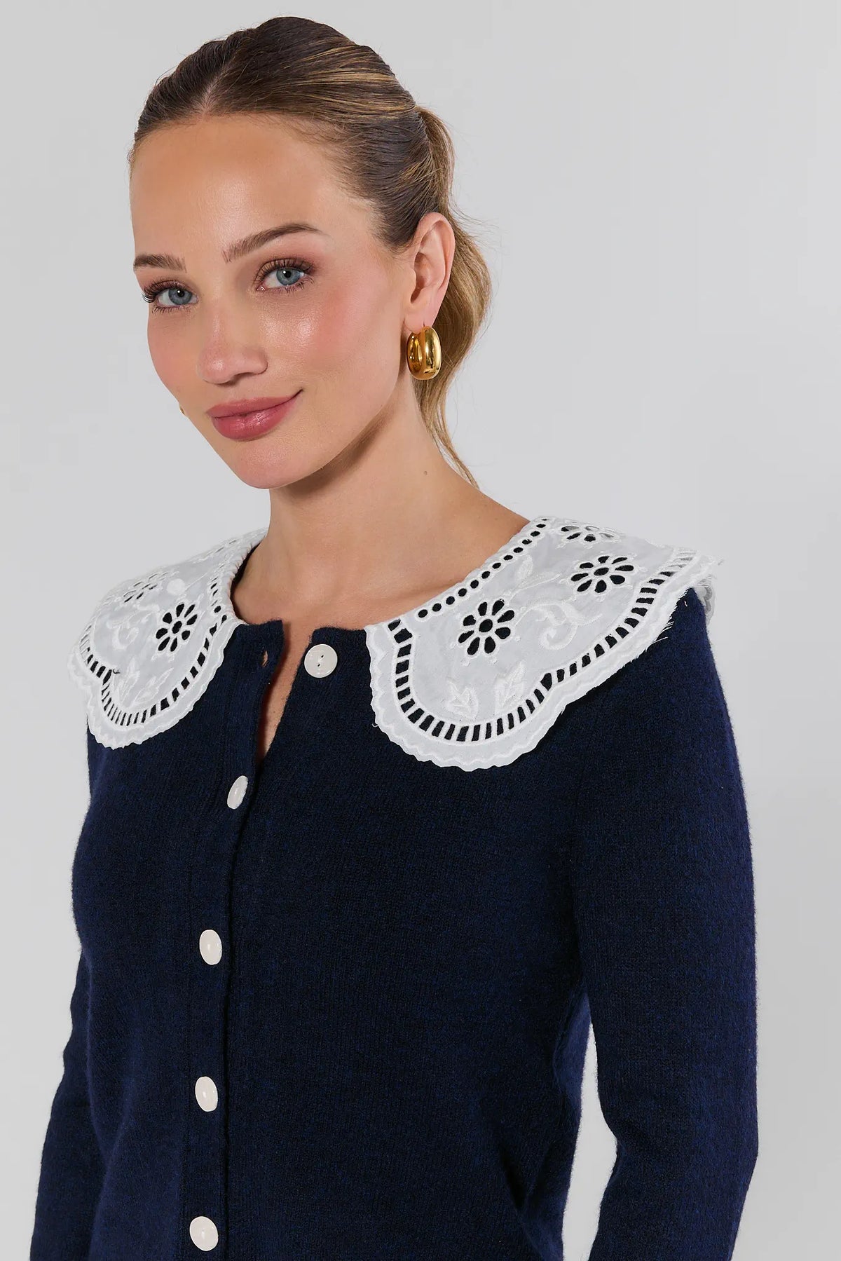 Close-up of navy cardigan with white floral eyelet Peter Pan collar detail - Side Angle | Avara