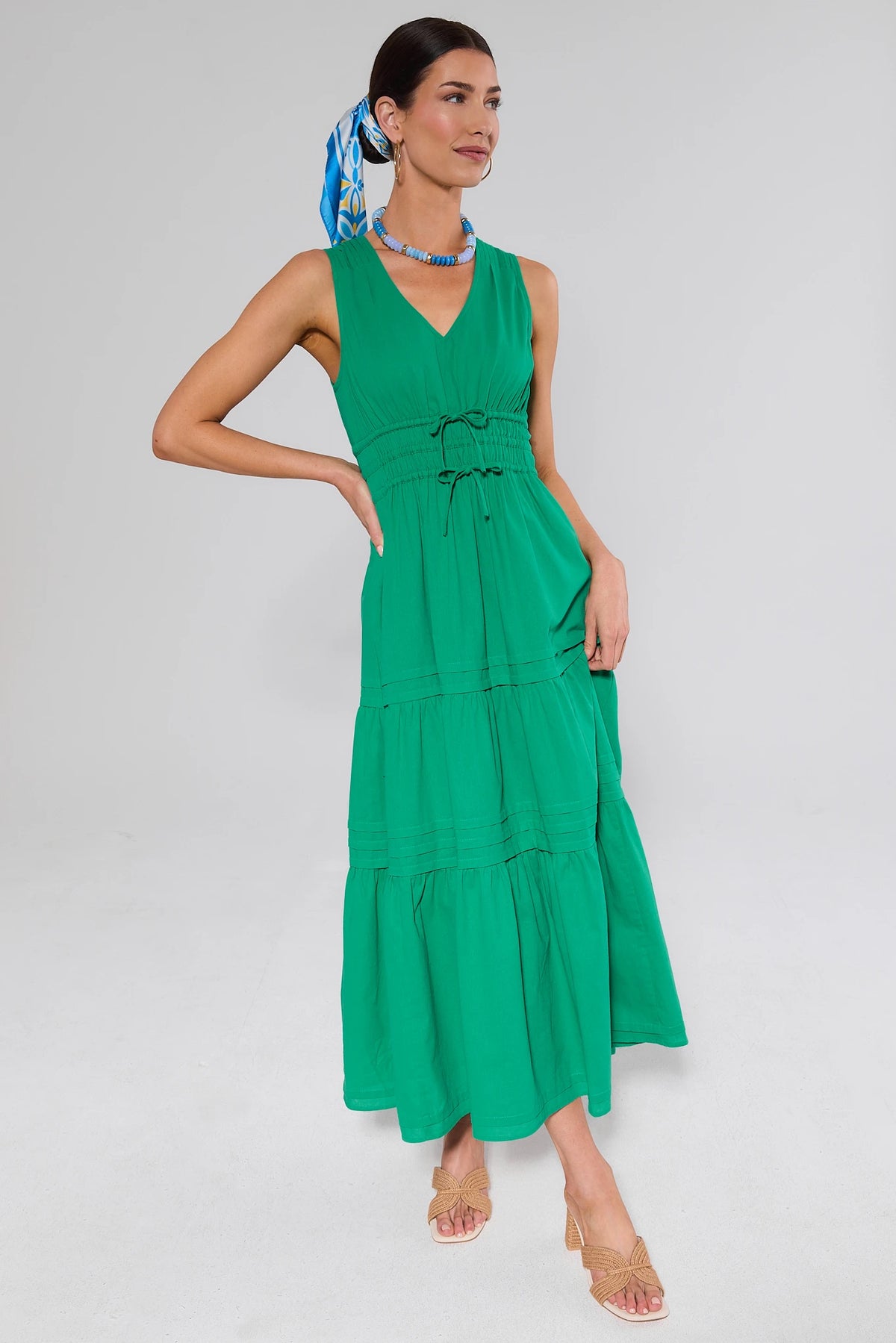 Green tiered maxi dress styled with blue scarf and beaded necklace - Side View On Model | Avara