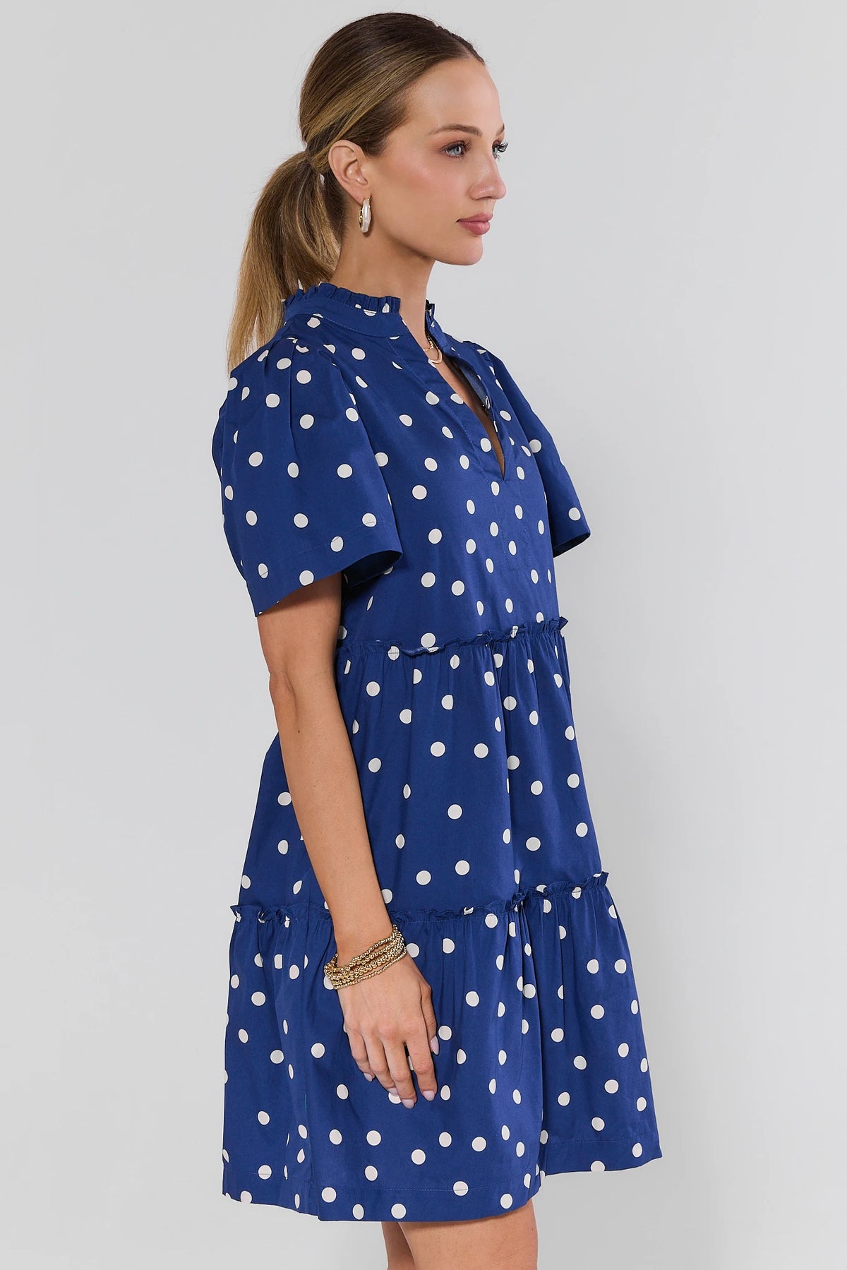 Evan Navy Polka Dot Short Dress - side profile showing puff sleeves, tiered ruffle skirt, knee length | Avara