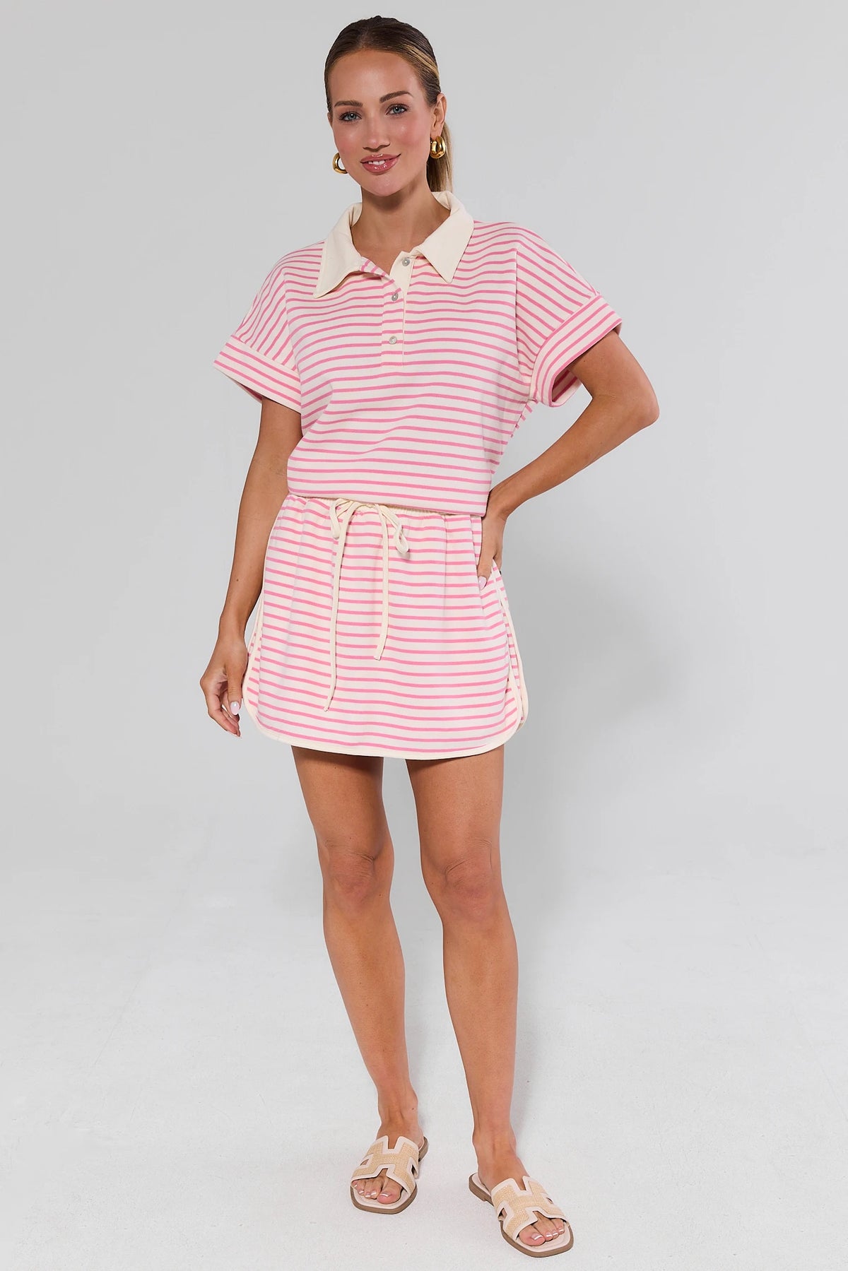 Pink and white striped mini skirt with elastic waist, on-model back view | Avara