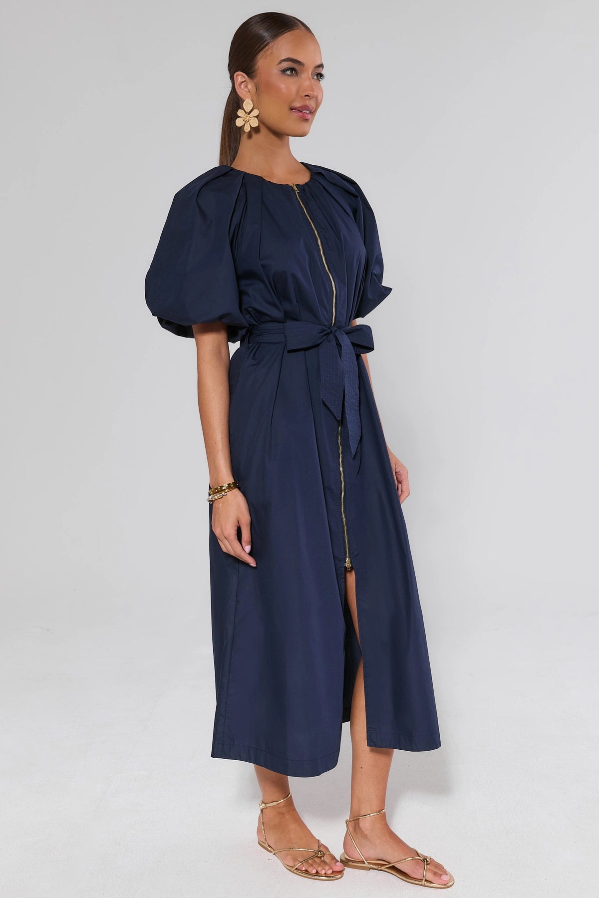 Side view of navy belted midi dress with voluminous puff sleeves, zip front, and bow tie waist | Avara