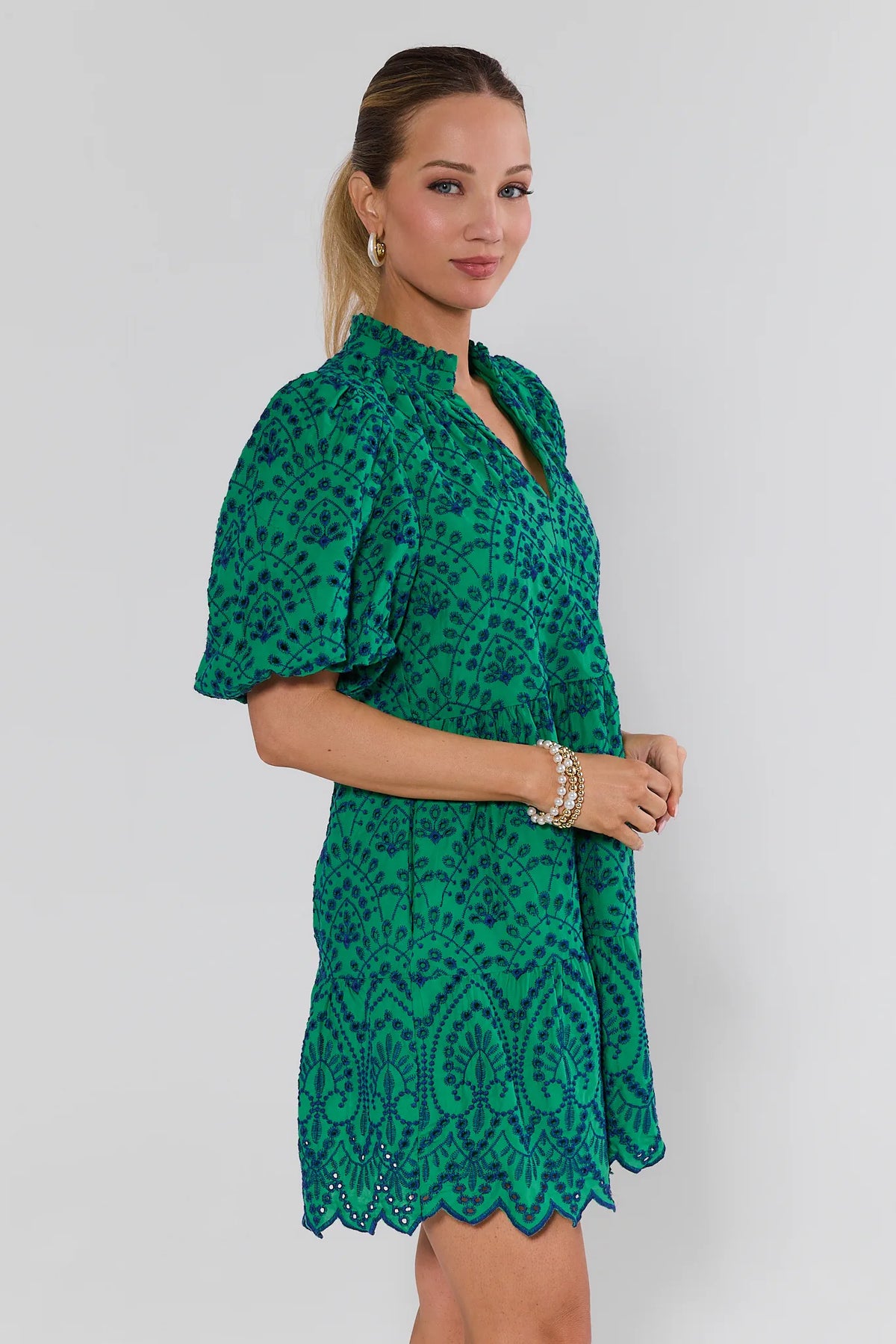Woman wearing a green patterned dress against a white background