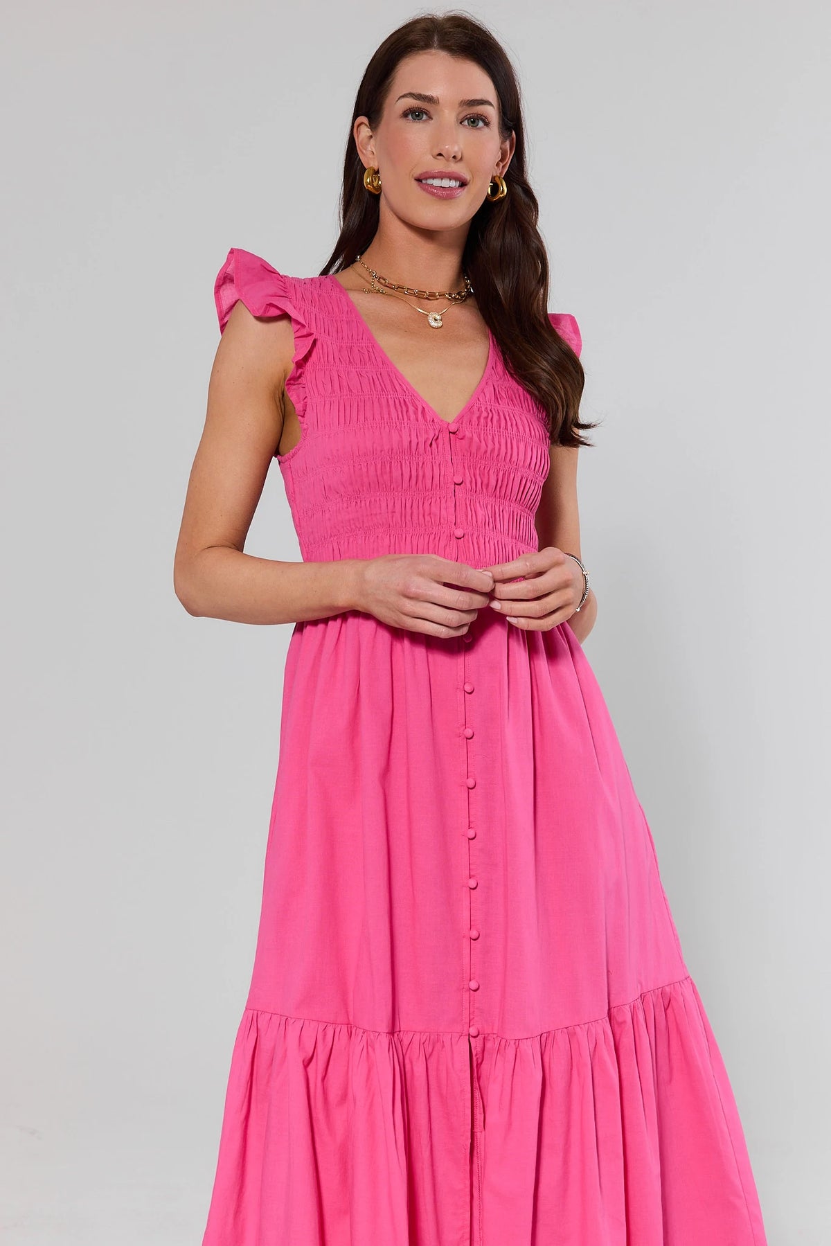 Pink Smocked Midi Dress with ruffle sleeves and button-front bodice, front view on model | Avara