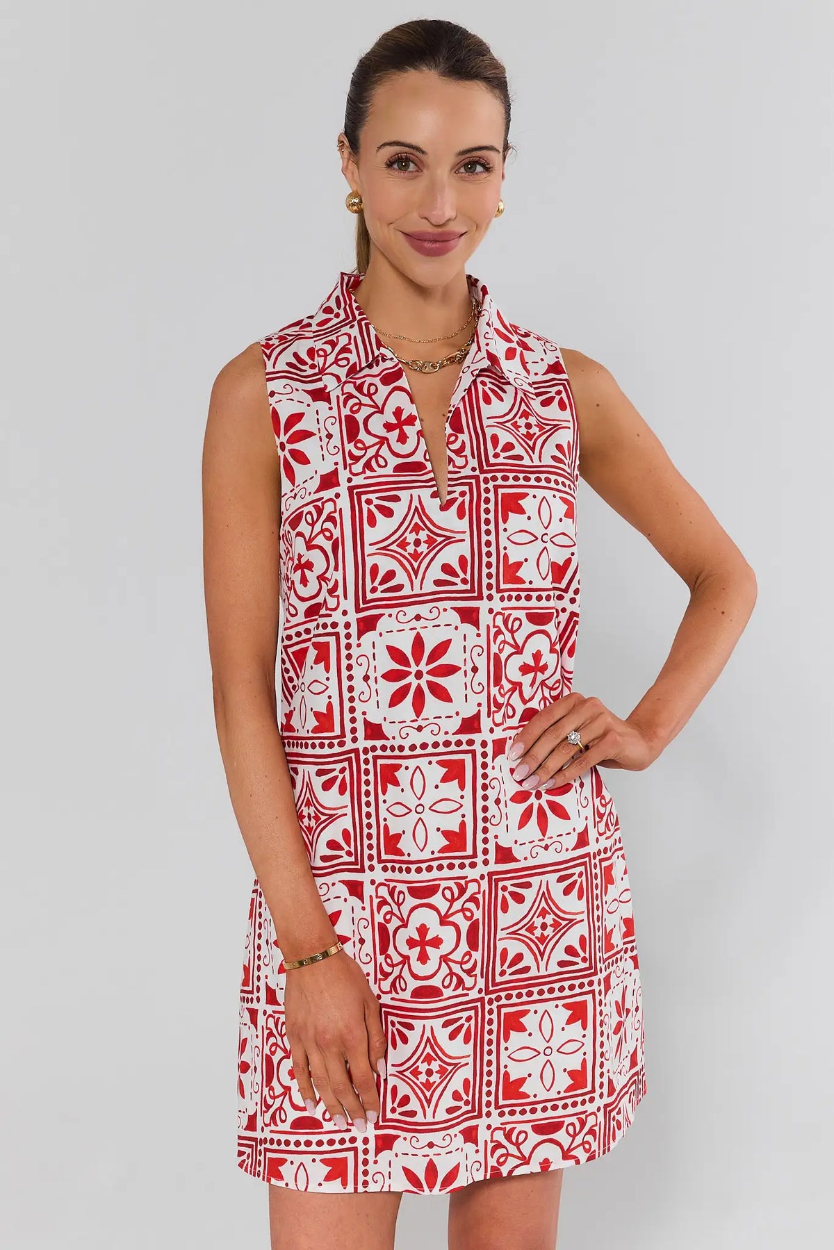 Woman wearing a red and white patterned dress against a plain background