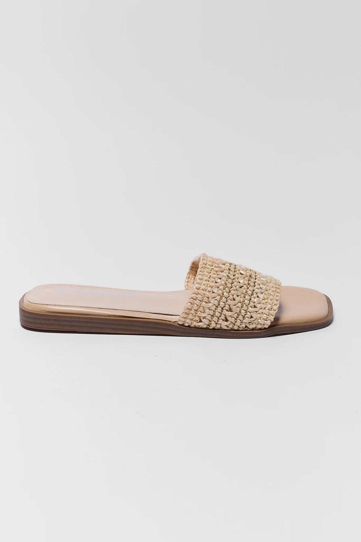 Beige sandal with textured strap on a light gray background