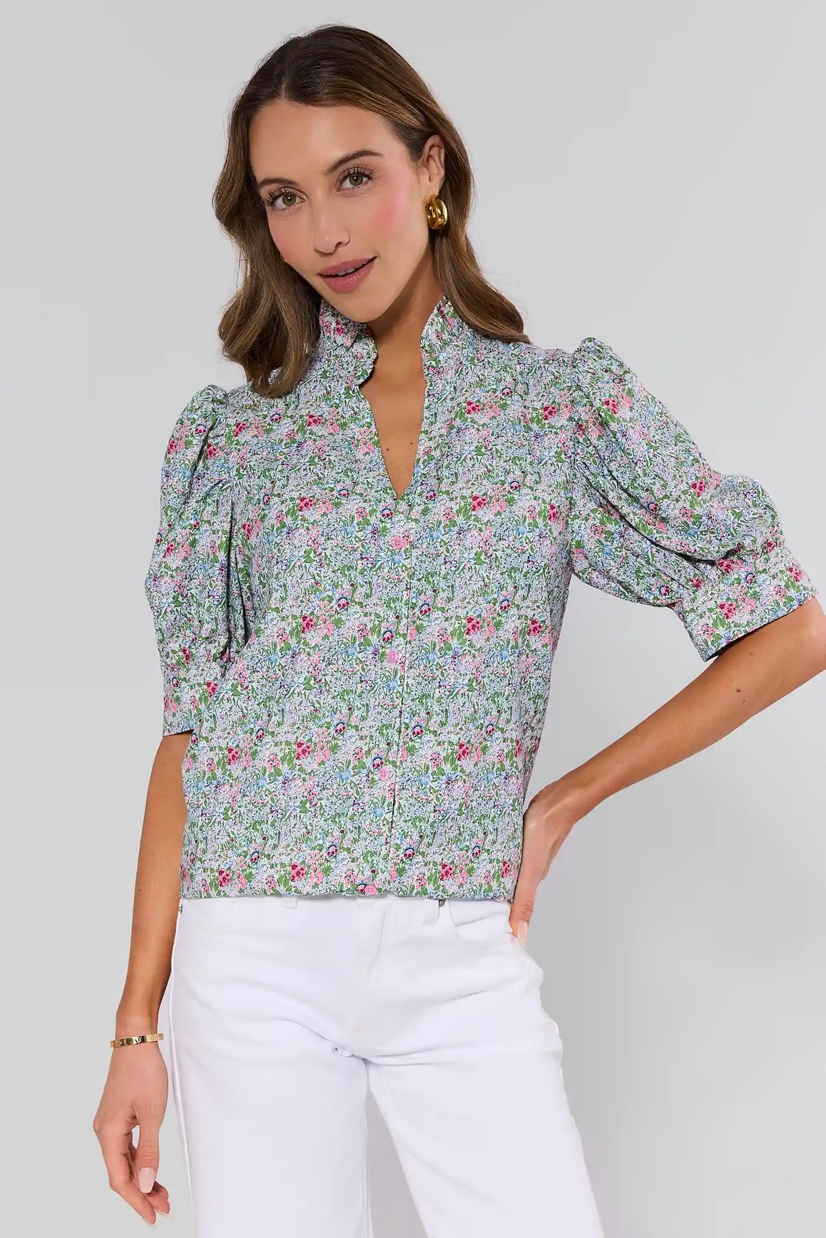 Woman wearing a floral blouse with puff sleeves against a white background