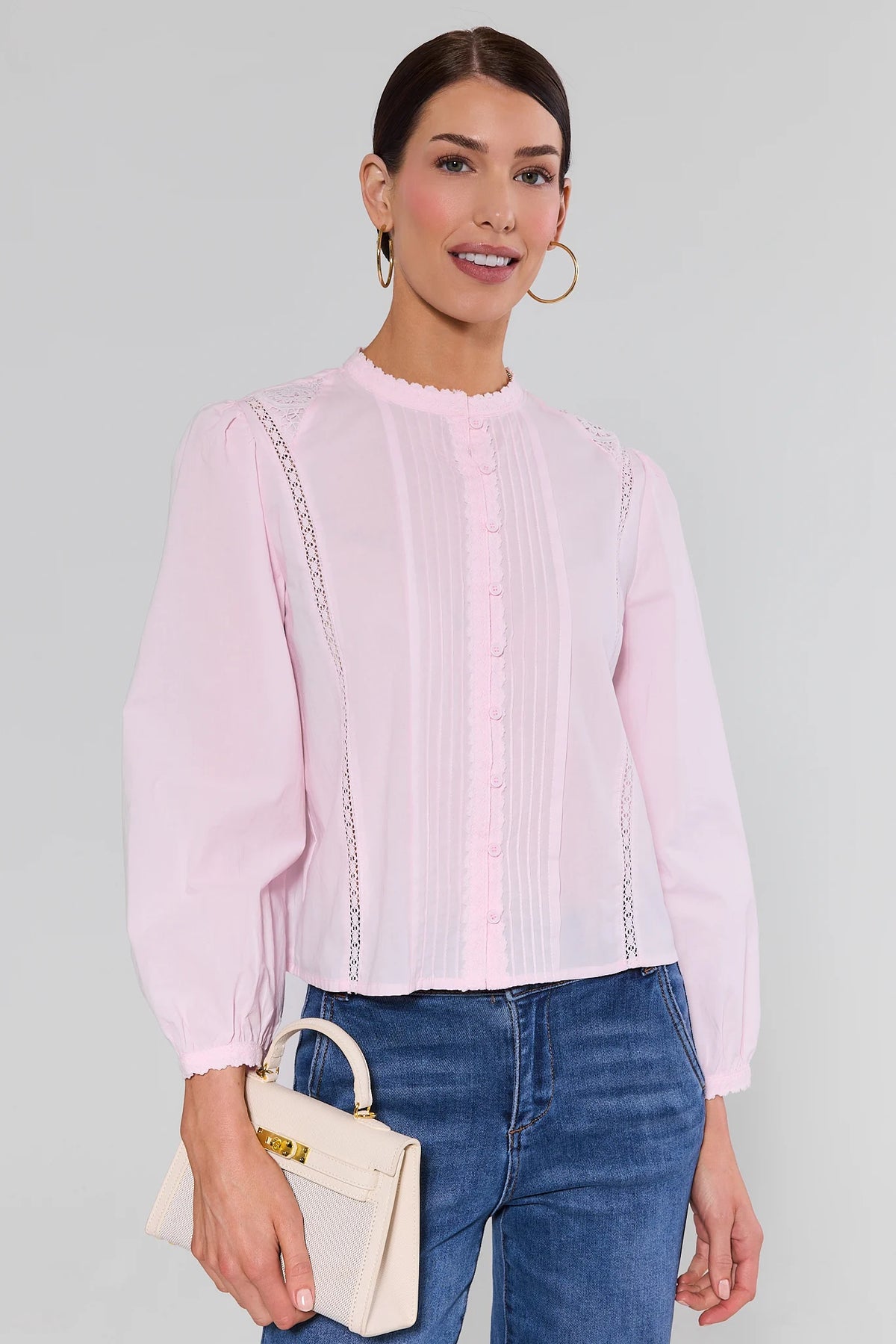 Woman wearing a light pink blouse with a white background