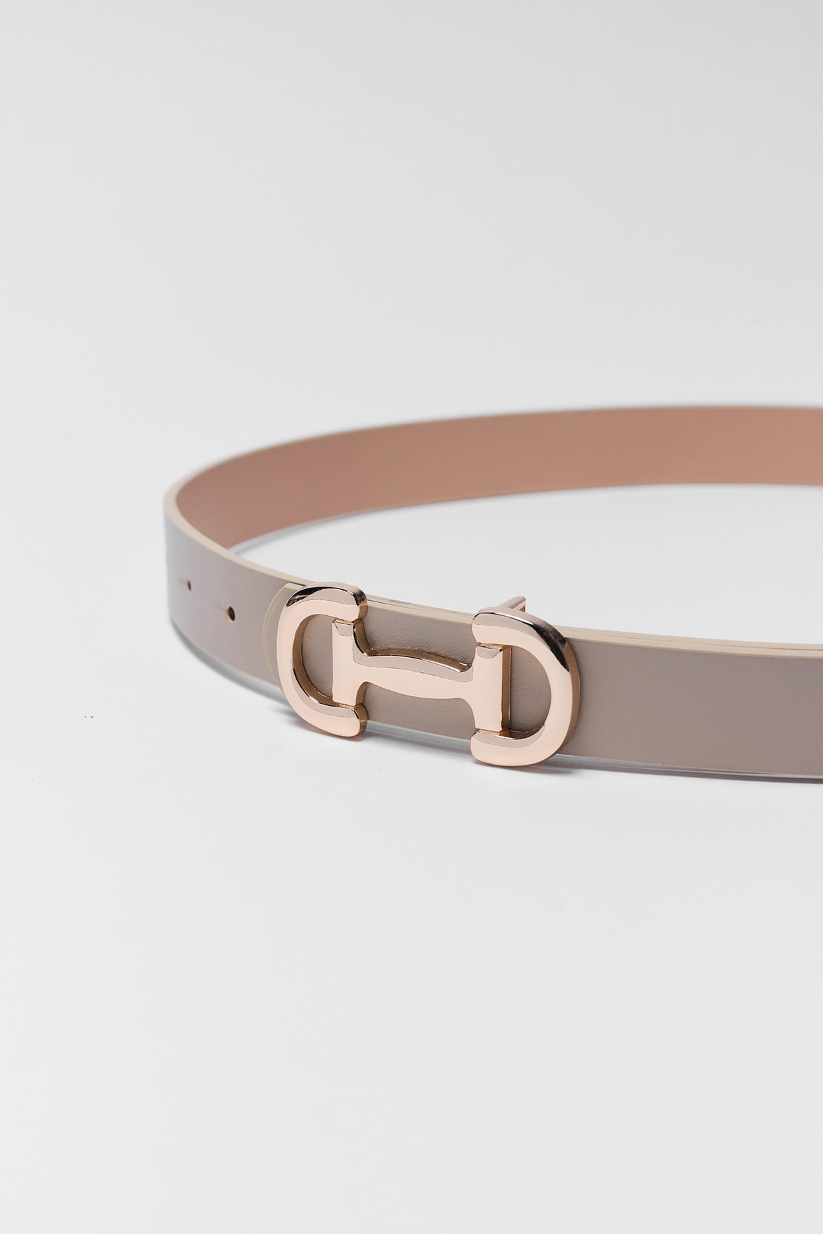 Belt with a gold buckle on a light gray background