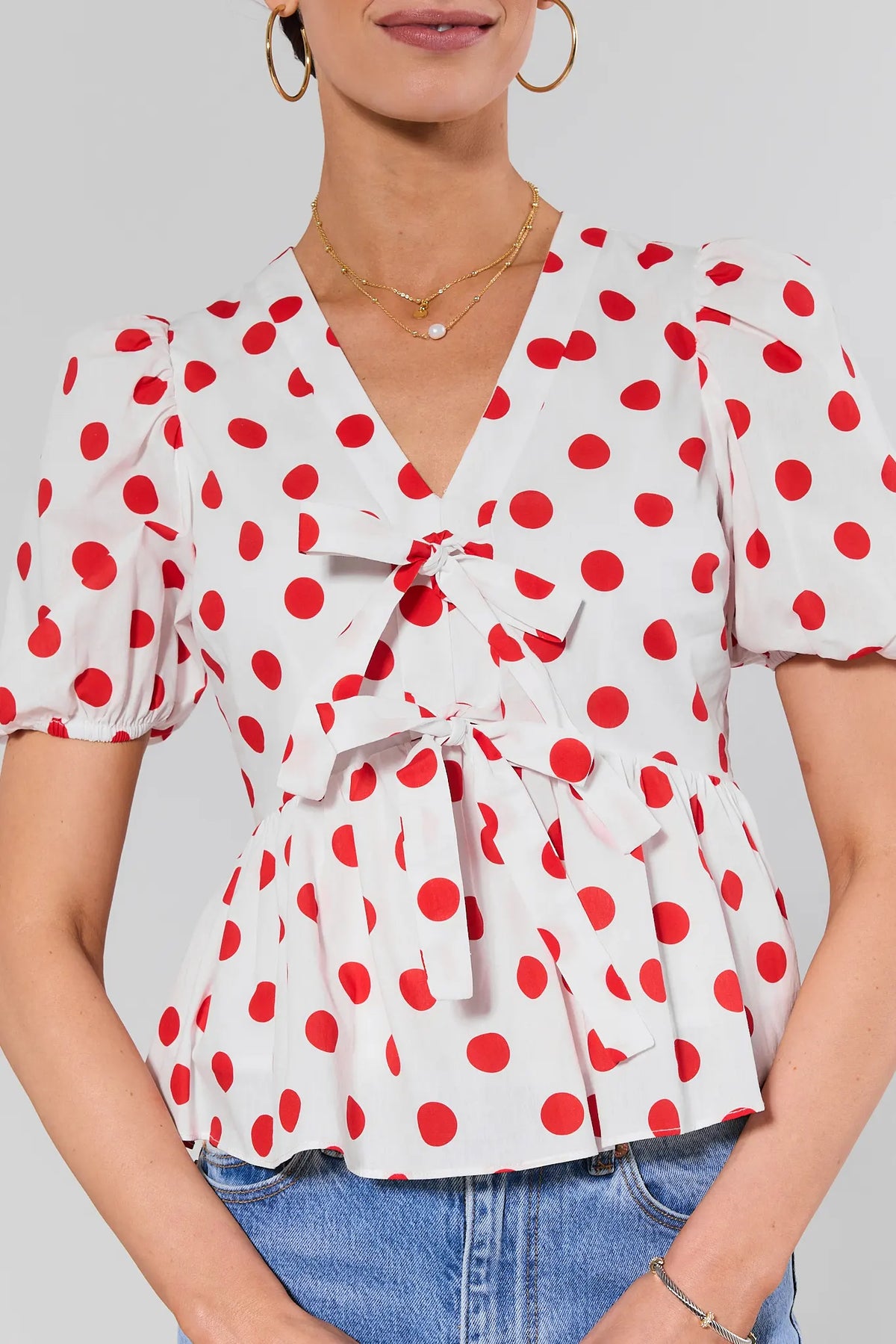 Georgie Red Polka Dot Peplum Top close-up showing bow detail and V-neckline | Avara