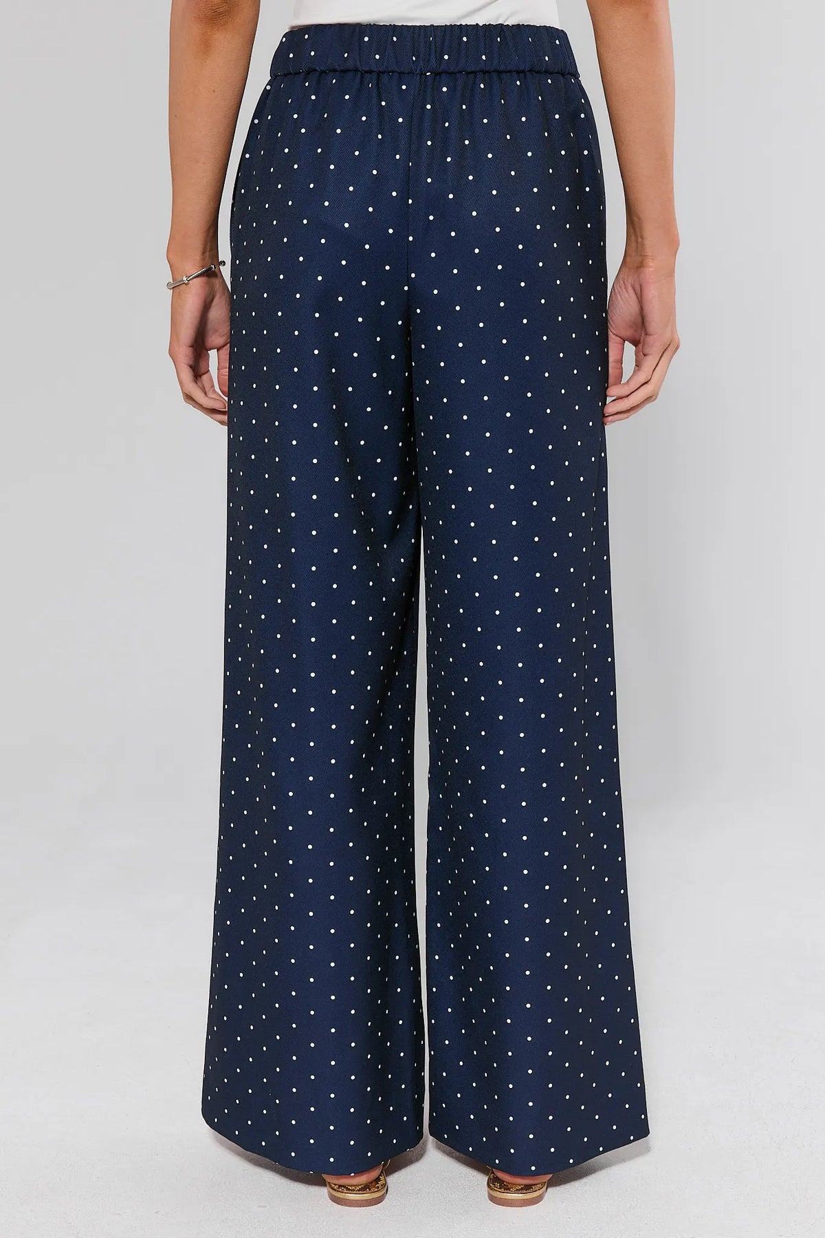 Navy blue polka dot wide-leg pants back view showing elastic waistband and full-length flowy cut | Avara