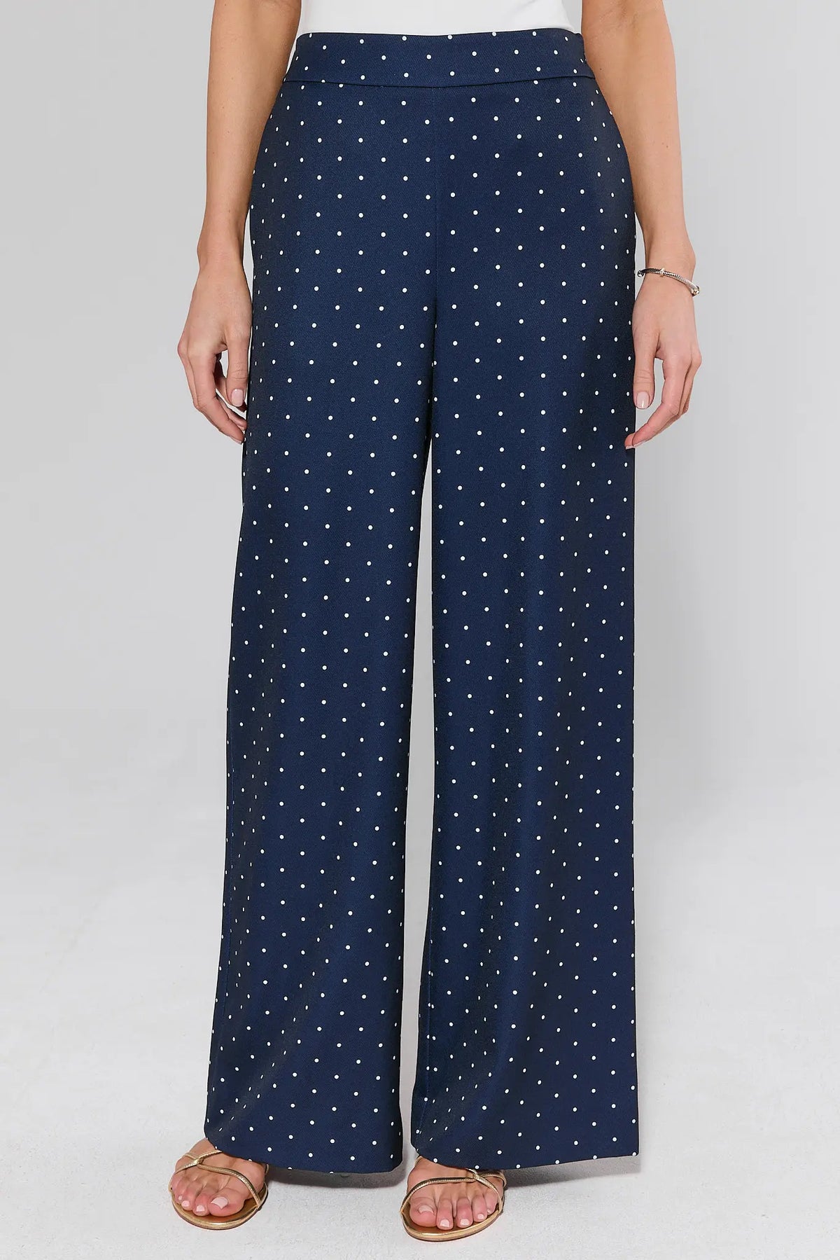 Navy blue polka dot wide-leg pants, front view, high-waist band with white dot print on model | Avara