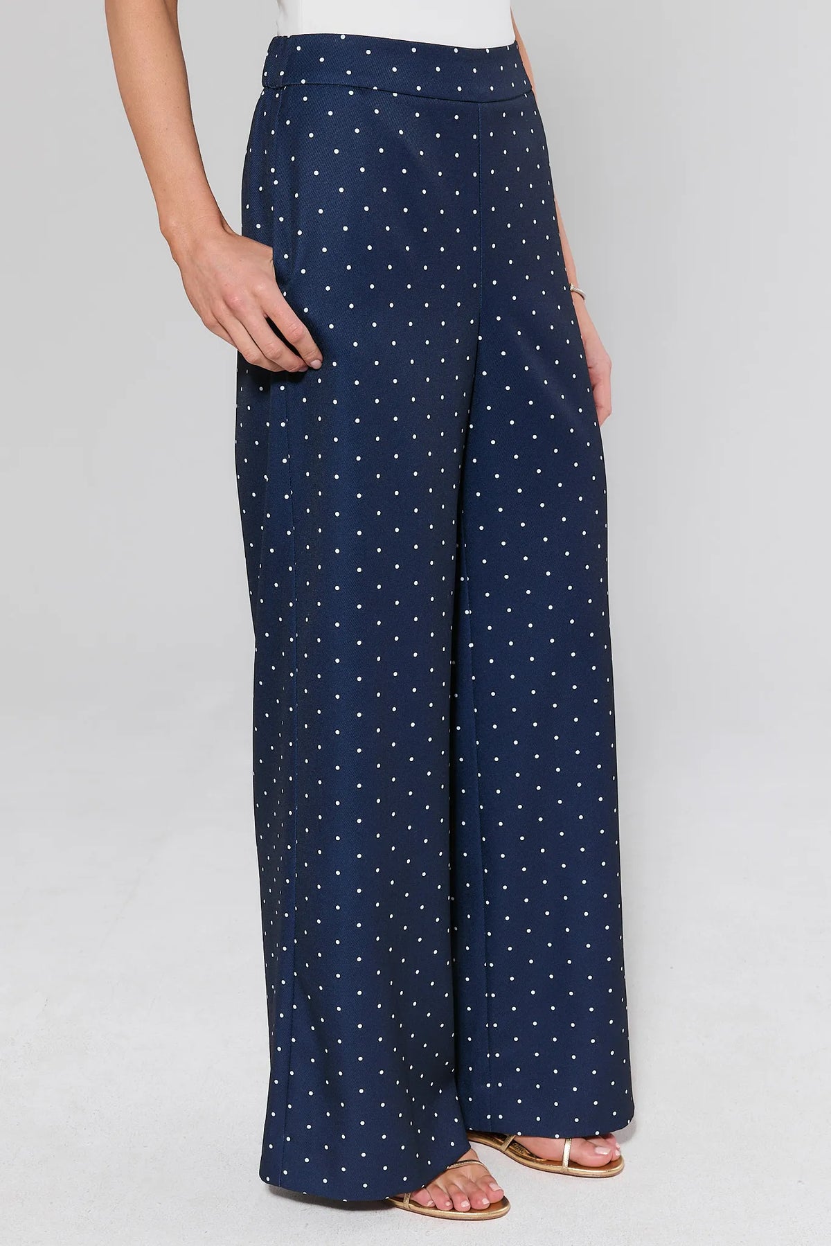 Navy polka dot wide-leg pants, side view showing flowy silhouette and high waist on model | Avara