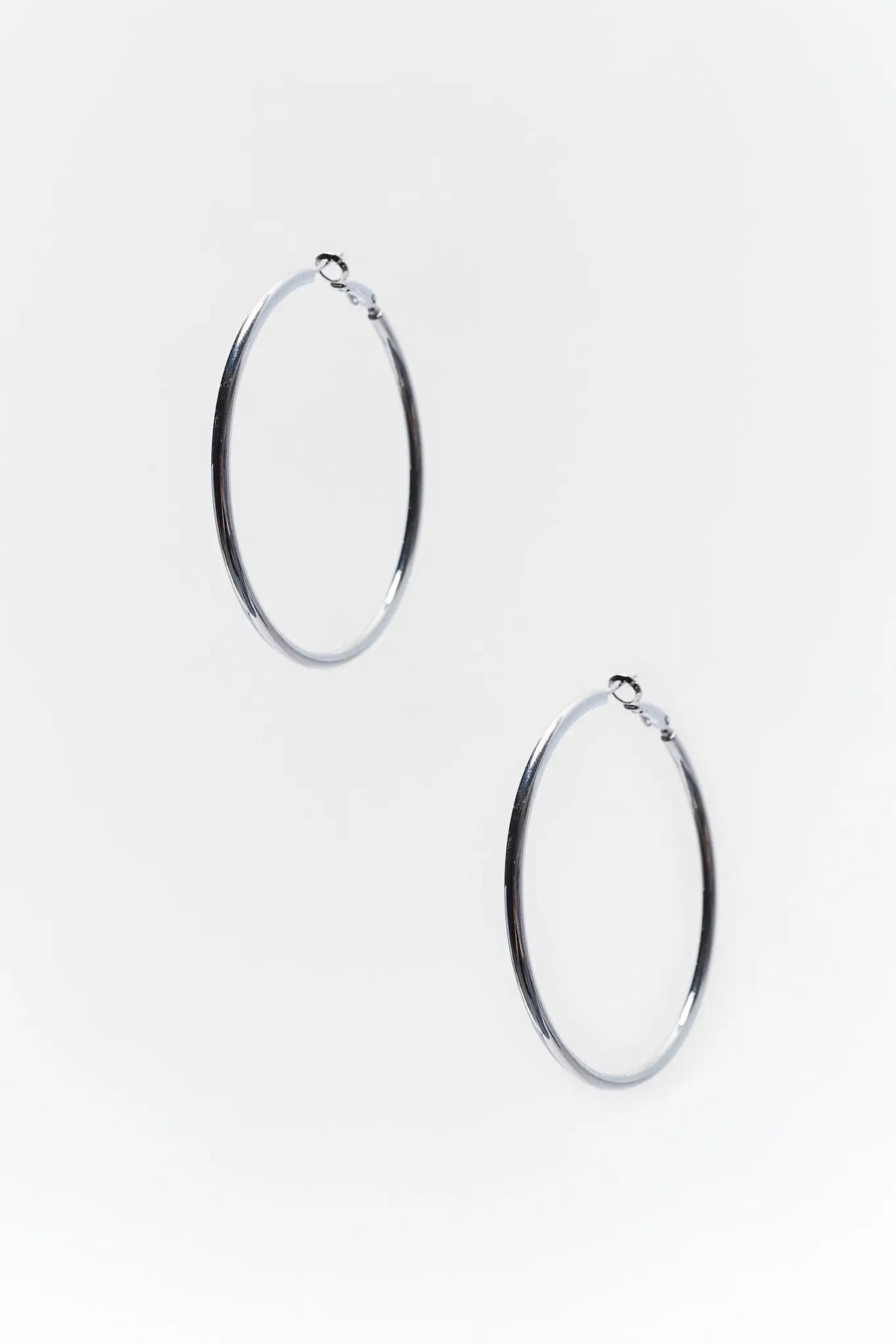 Pair of silver small hoop earrings with hinge backs on white background | Avara