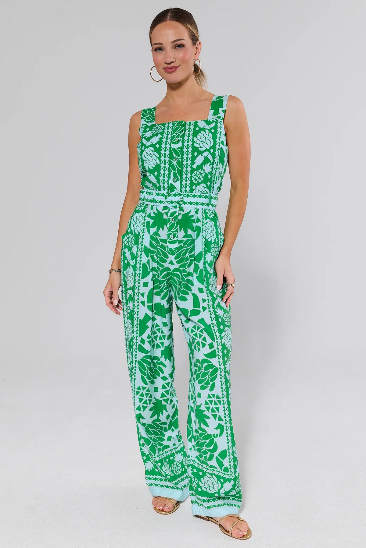 Woman wearing annabelle green and white patterned jumpsuit on a background