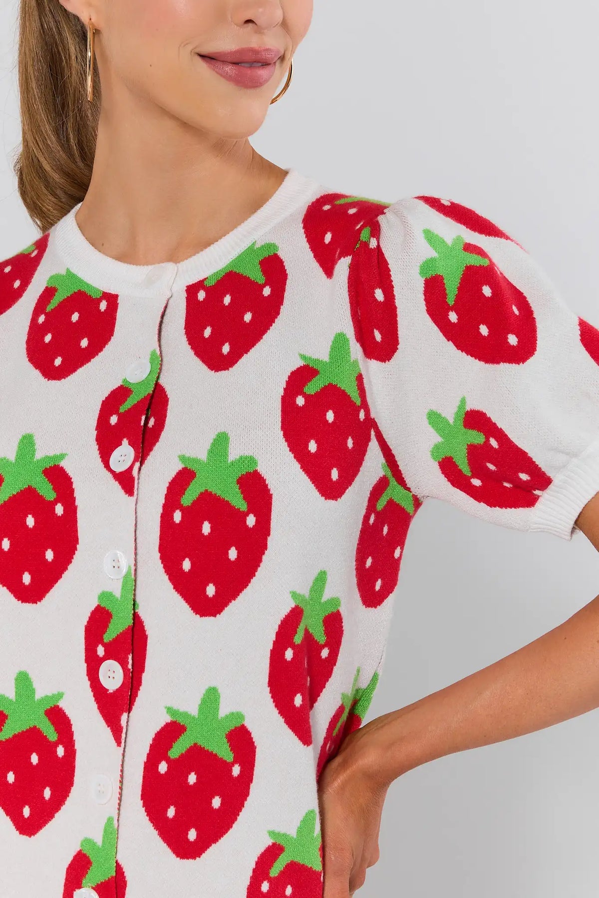 Close-up of white strawberry knit sweater showing intarsia print detail and button closure - Front Detail | Avara