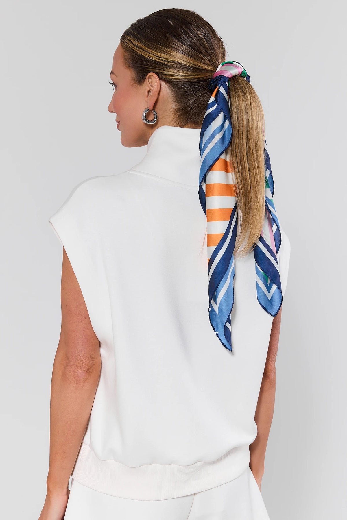 Woman with a colorful striped hair tie on a white background