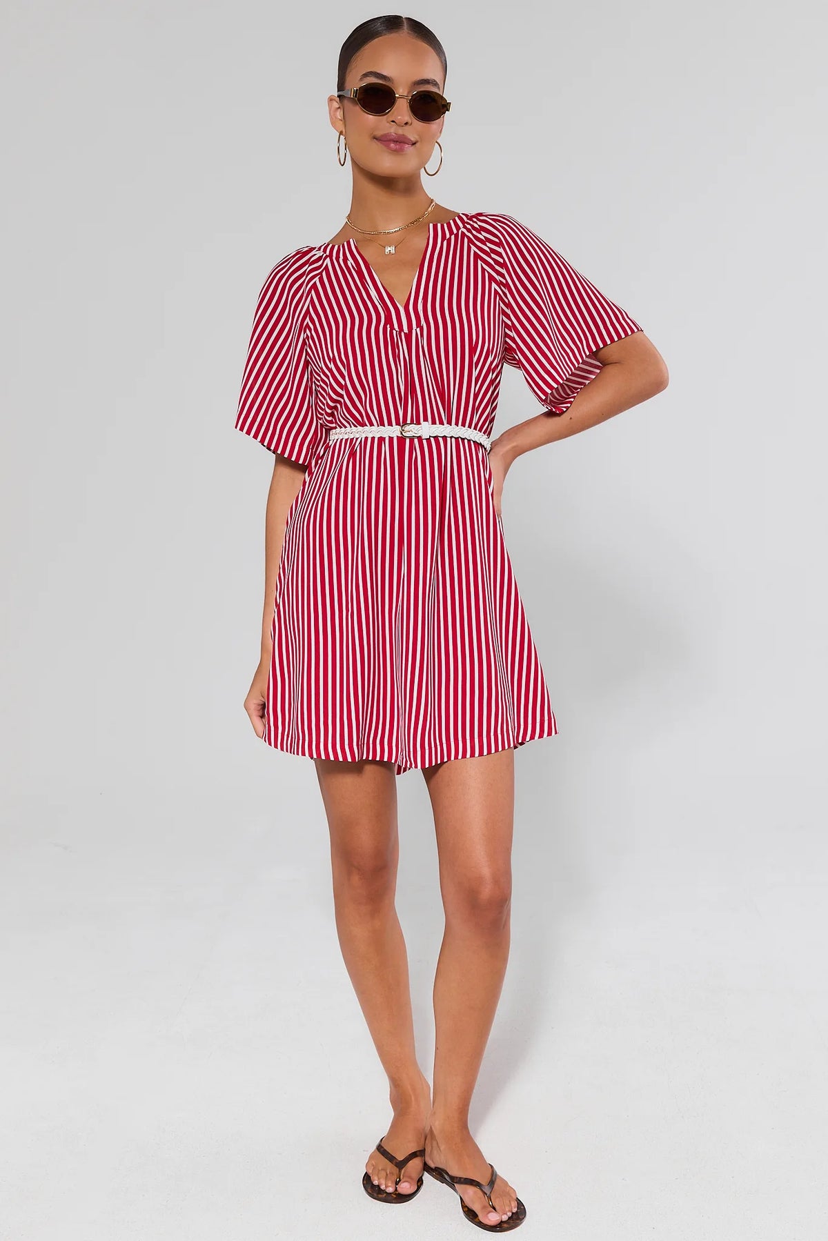 full body Woman wearing a red and white striped dress on a plain background